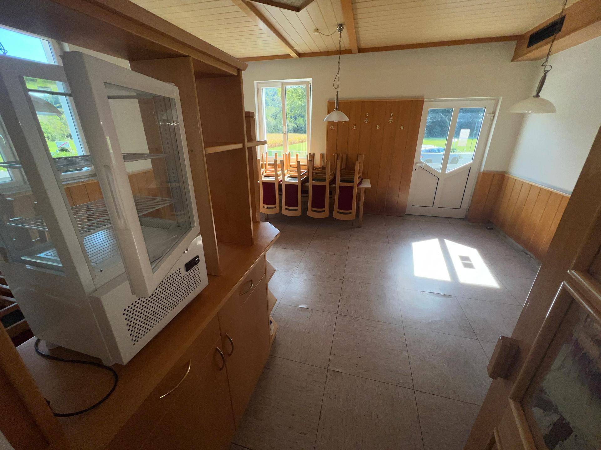 Speisesaal mit Tischen, Stühlen und einer Vitrine, bereit für den Betrieb.