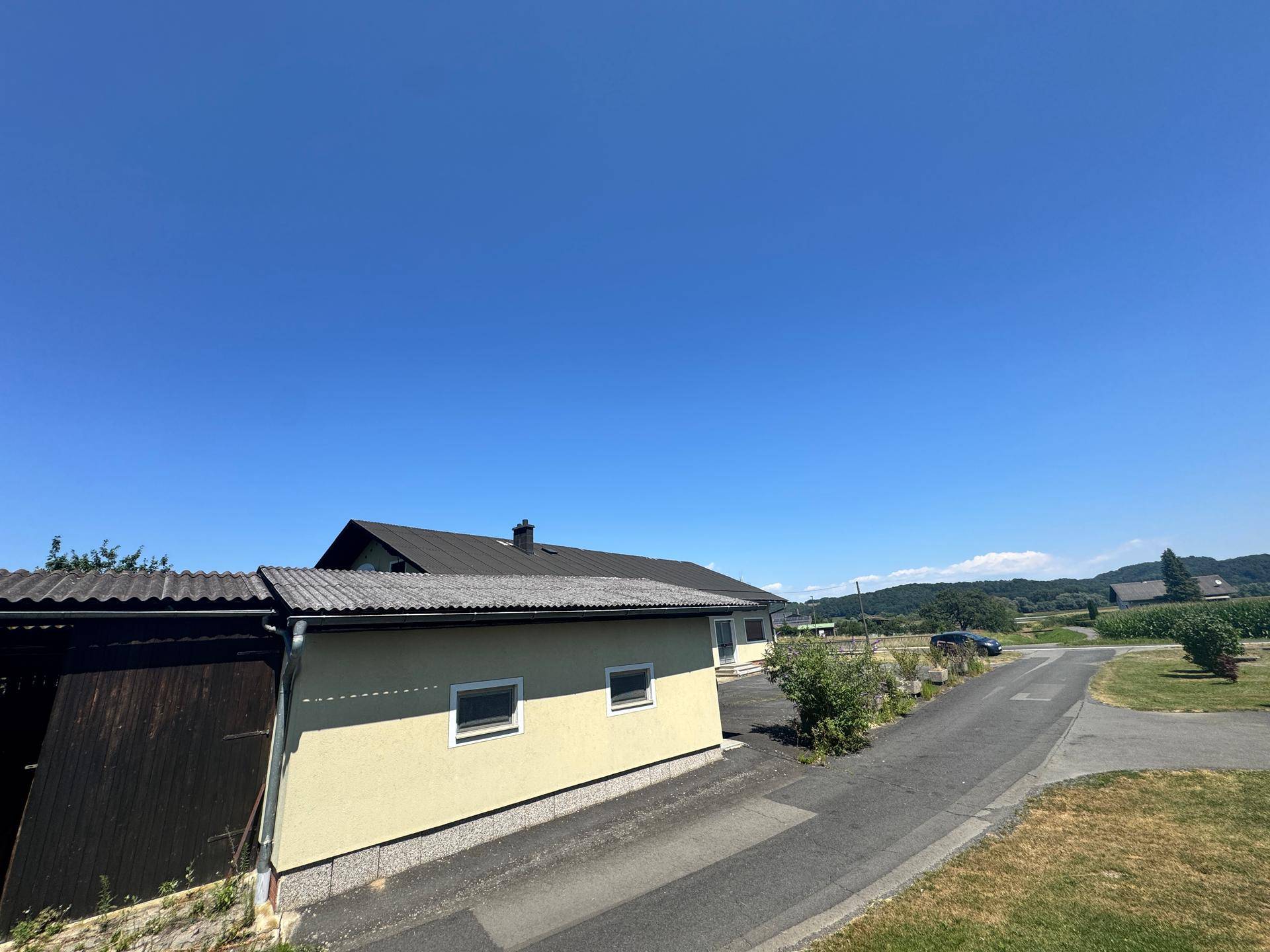 Seitenansicht des Hauses mit Garage und Blick auf die ländliche Umgebung.