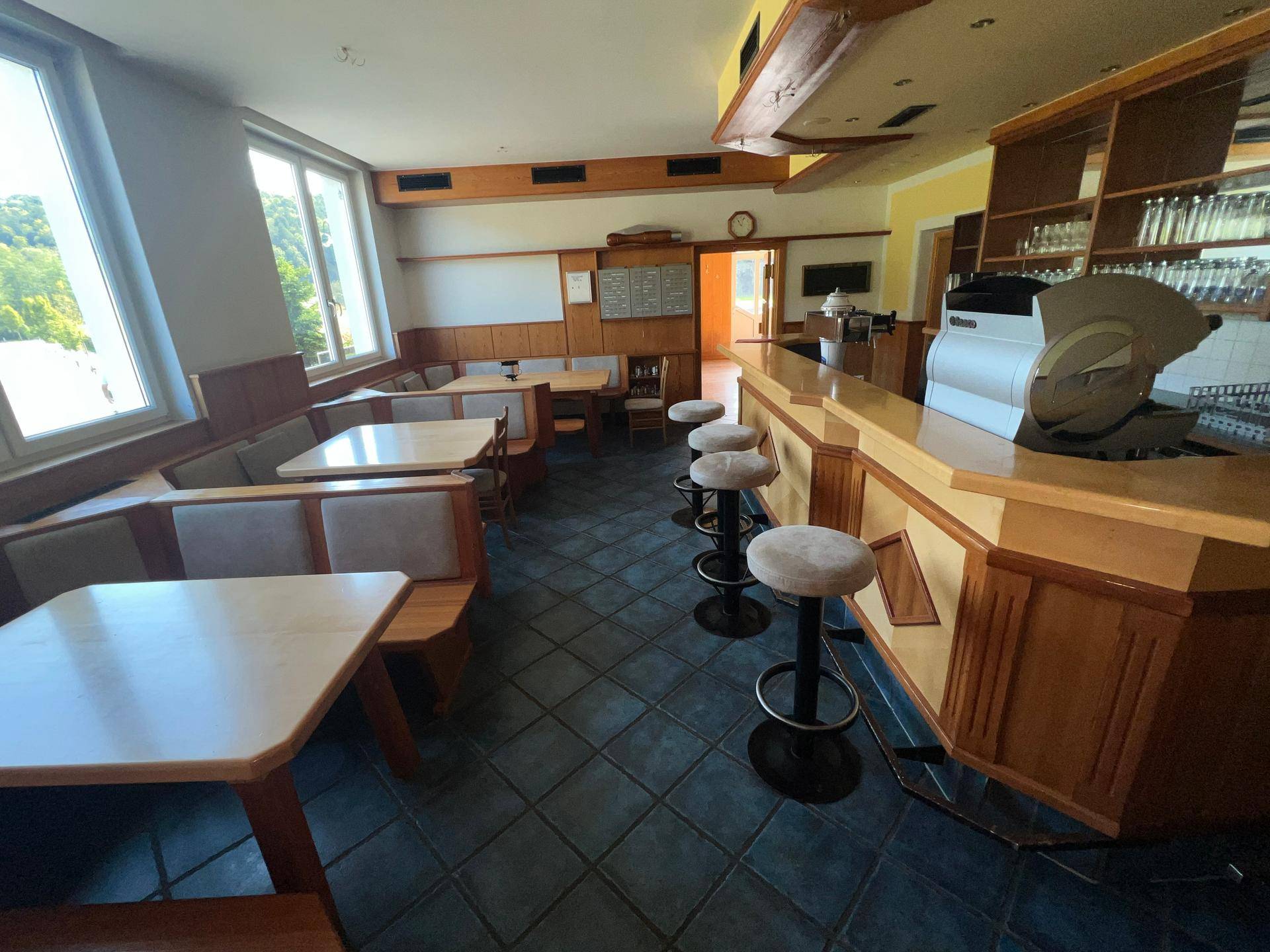 Gemütlicher Barbereich mit Holztischen, Bänken und Barhockern, ideal für gesellige Runden.