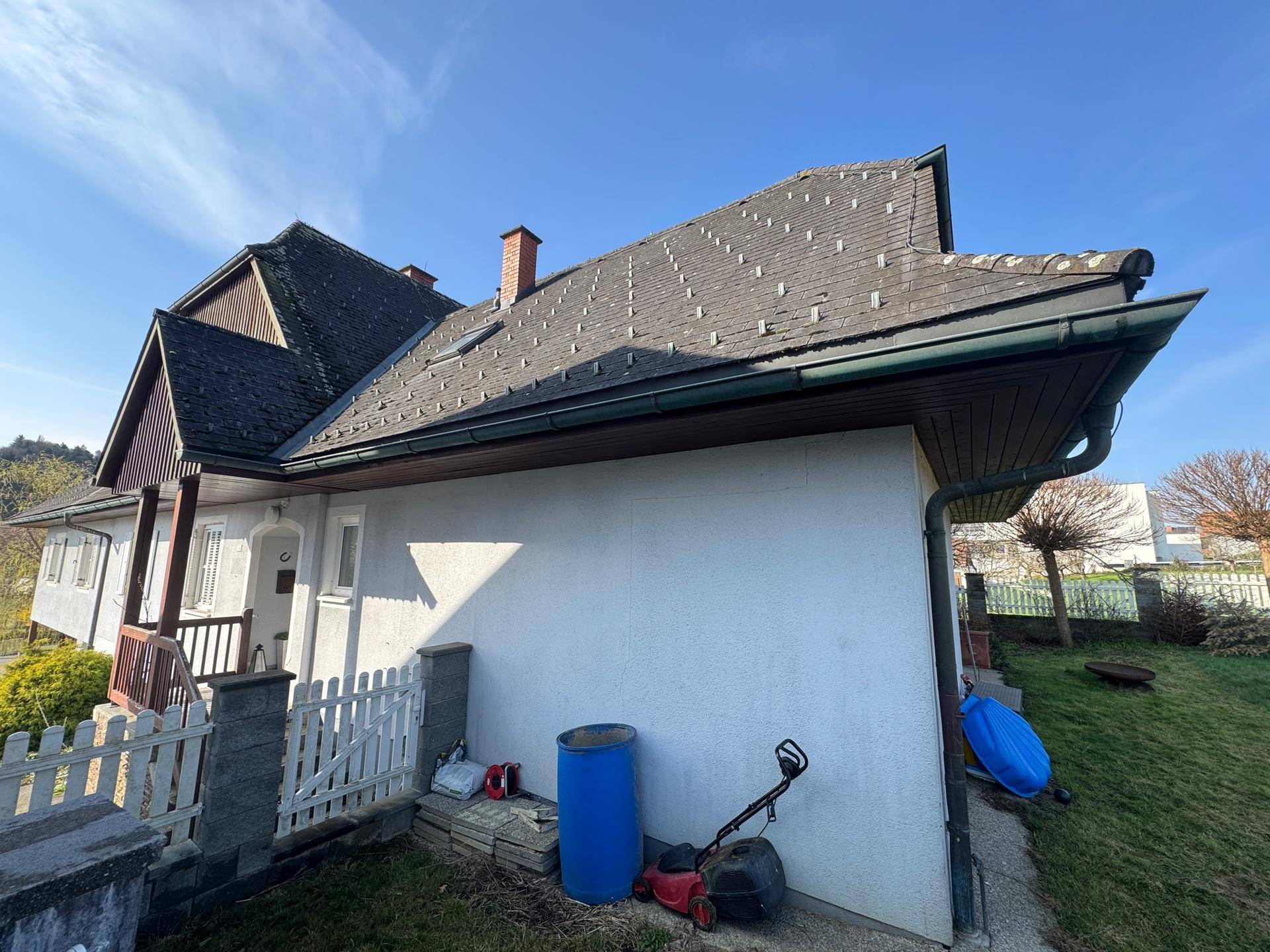 Seitenansicht des Hauses mit Dachüberstand und einem kleinen Vorgartenbereich.