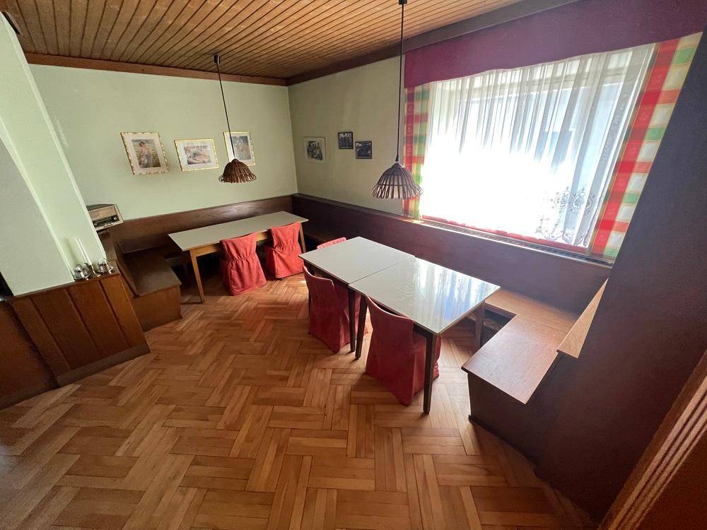 Gemütlicher Essbereich mit Holzboden, Holztäfelung und traditioneller Einrichtung, ideal für Gäste.