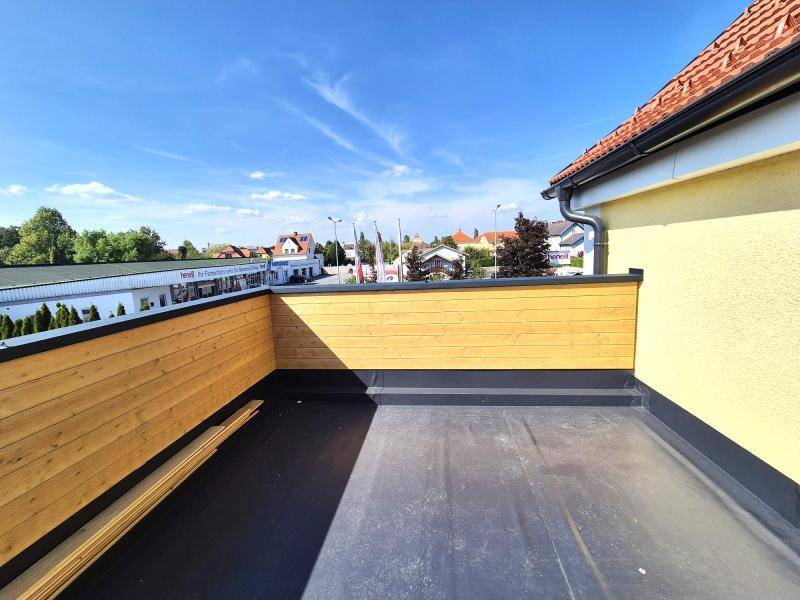 Geräumige Dachterrasse mit Holzsichtschutz und weitem Blick über die Umgebung.