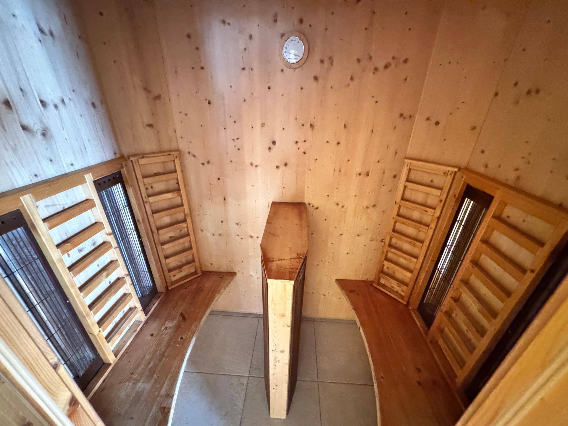 Helle Sauna mit Holzverkleidung und Sitzbänken.