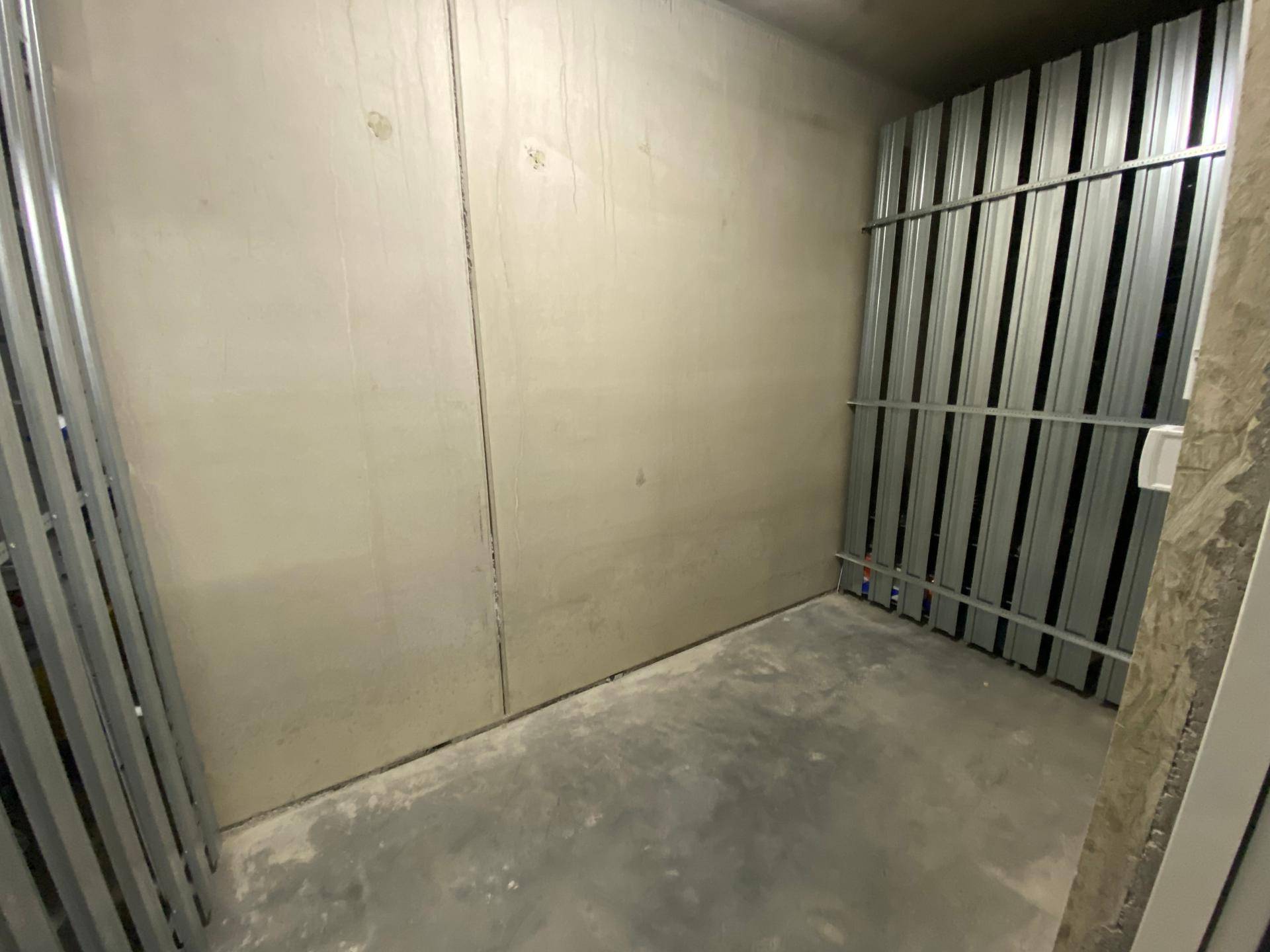 Geräumiges Kellerabteil mit Betonboden und Metallabtrennungen für sichere Lagerung.
