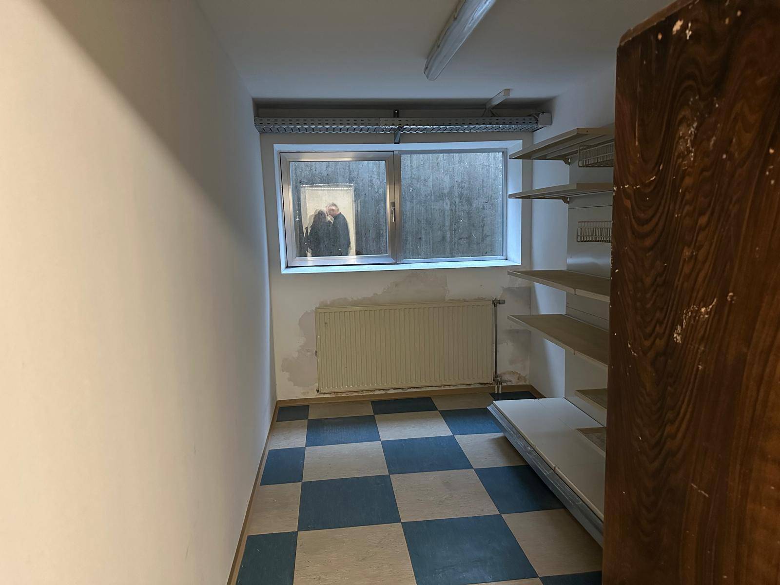 Lagerraum im Keller mit Fenster, Heizkörper und Regalen.