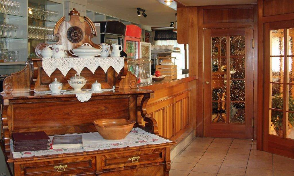 Traditioneller Empfangsbereich mit Holzmöbeln und gefliestem Boden.