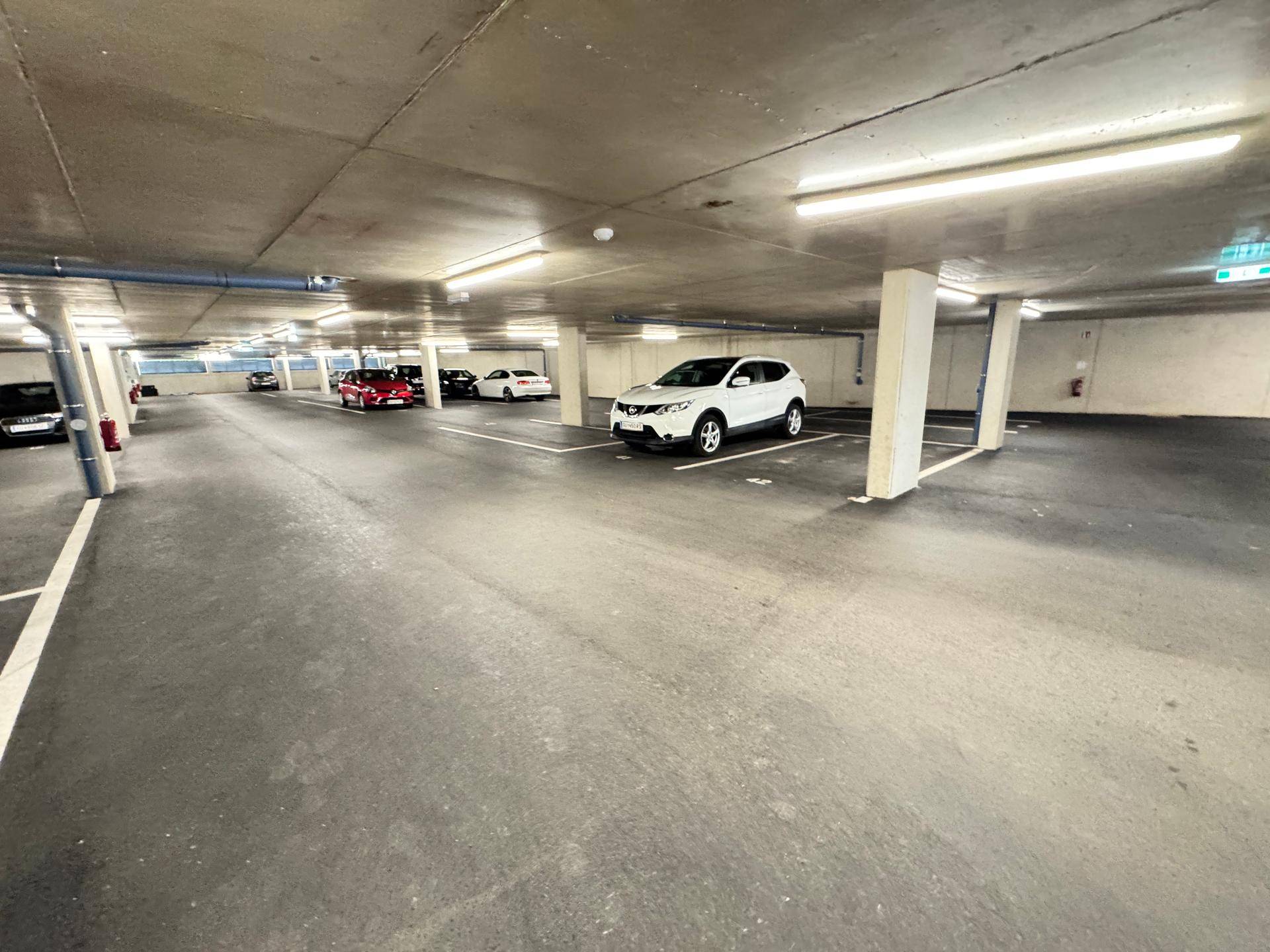 Geräumige Tiefgarage mit markierten Parkplätzen und guter Beleuchtung, bietet sicheren Stellplatz.