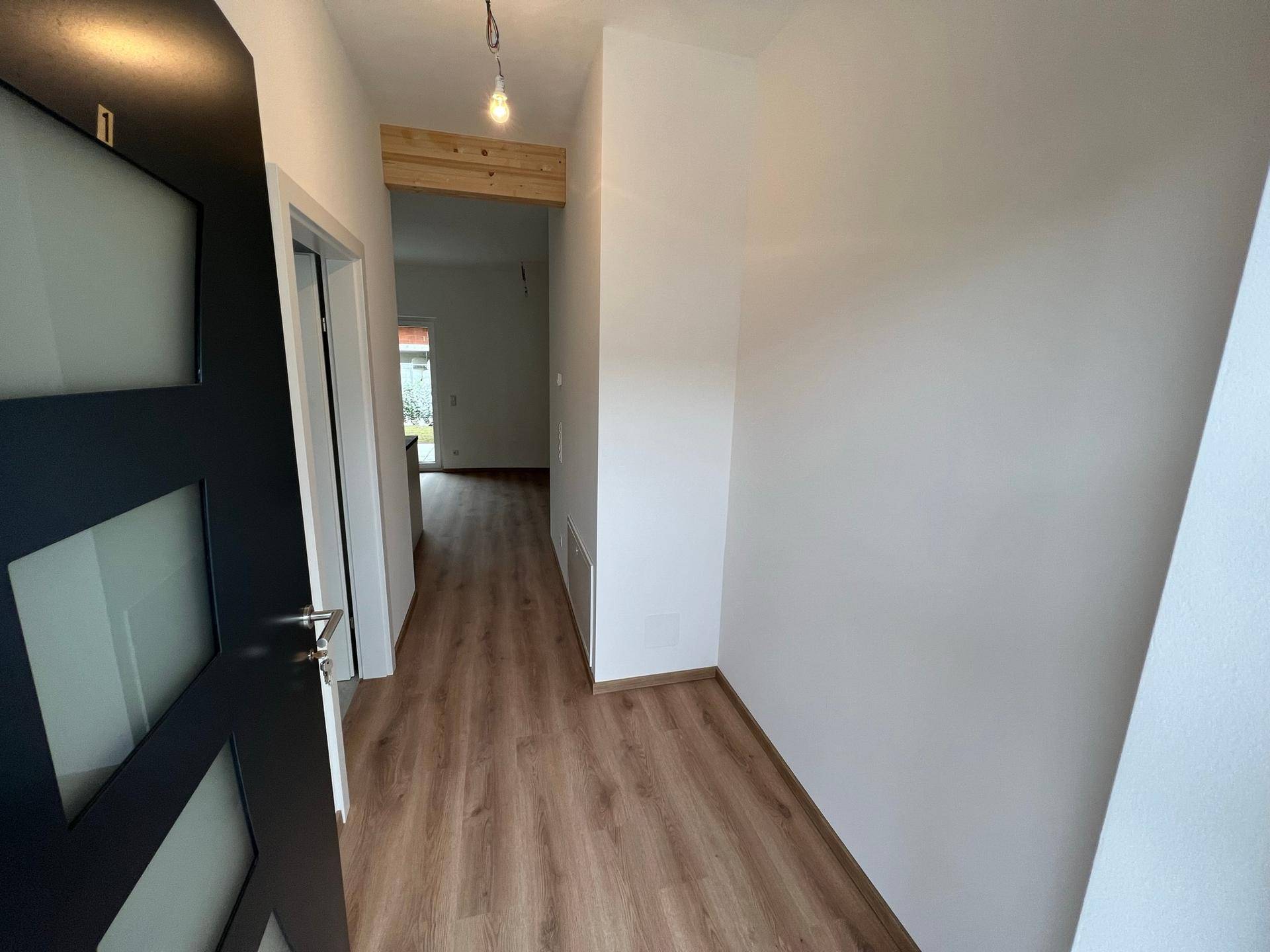 Heller Eingangsbereich mit Laminatboden und Blick in den offenen Wohnbereich.