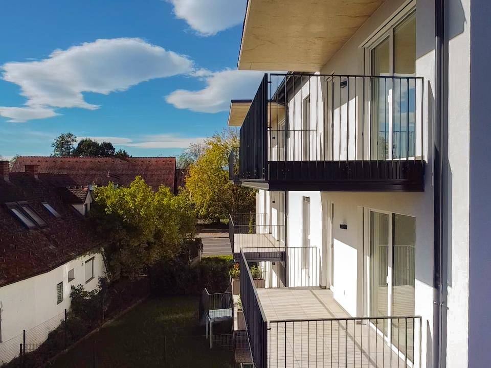 Geräumiger Balkon mit Fliesenboden und Blick auf die umliegende Wohngegend.