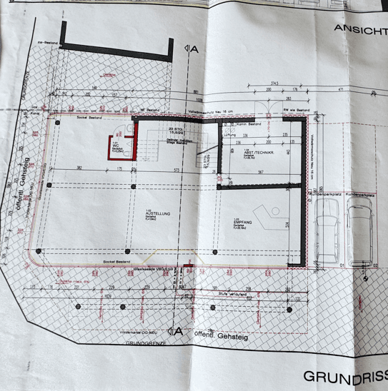 Detaillierter Grundriss des Erdgeschosses mit Empfangsbereich, Ausstellung und Kundenparkplätzen, gut strukturiert.