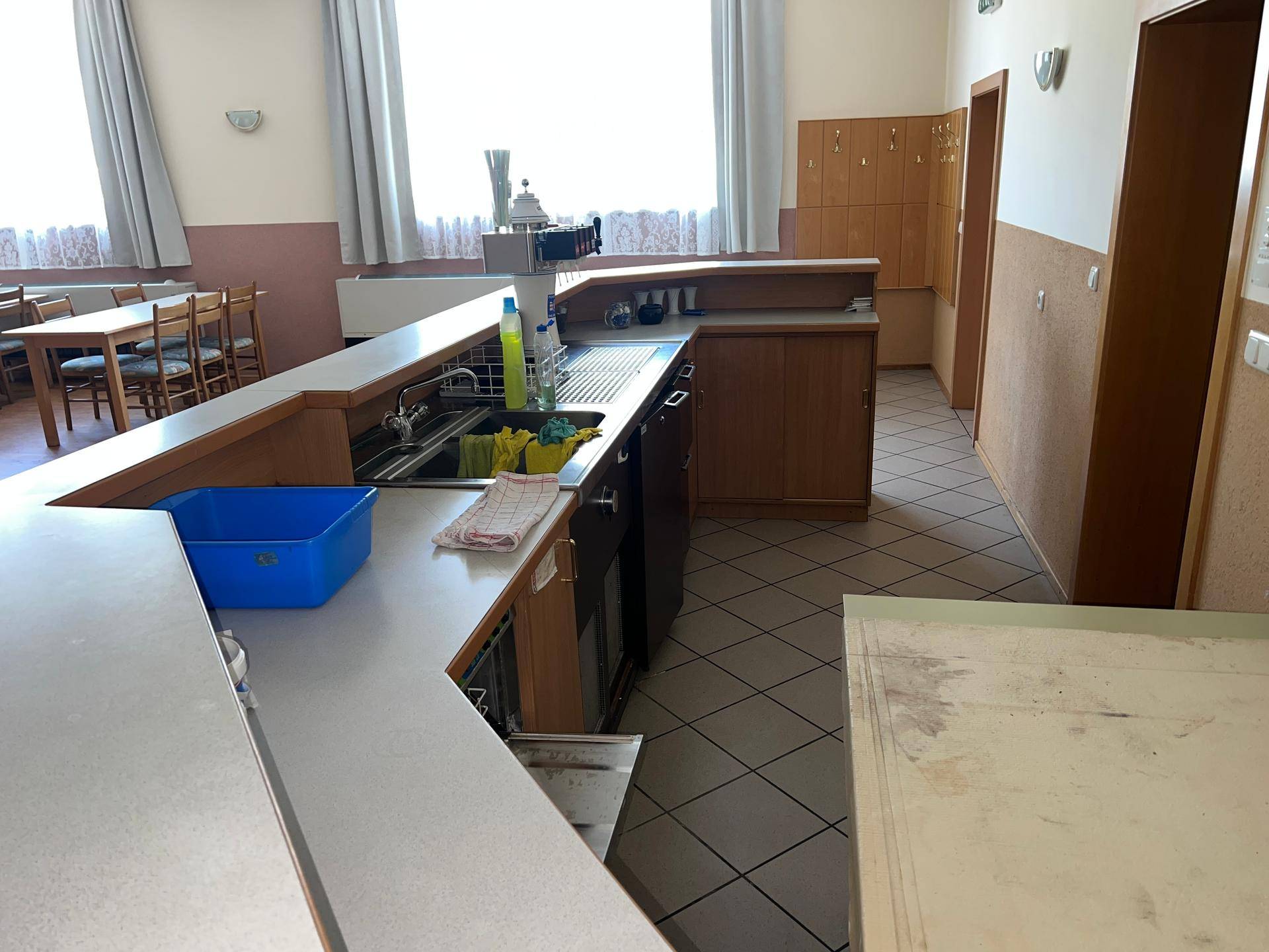 Barbereich mit Spülbecken, Theke und Blick auf den Speisesaal, bereit für den Betrieb.