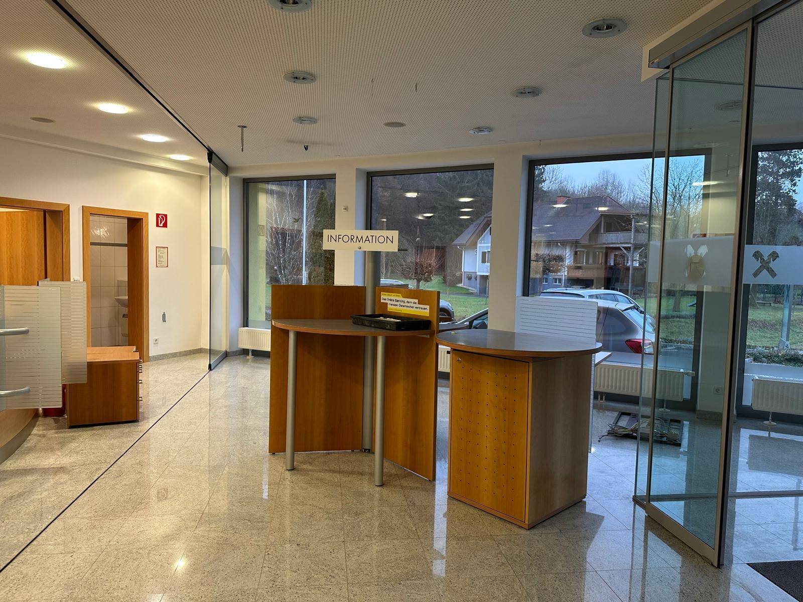 Empfangsbereich mit Informationsschaltern, großen Fenstern und Blick ins Grüne.