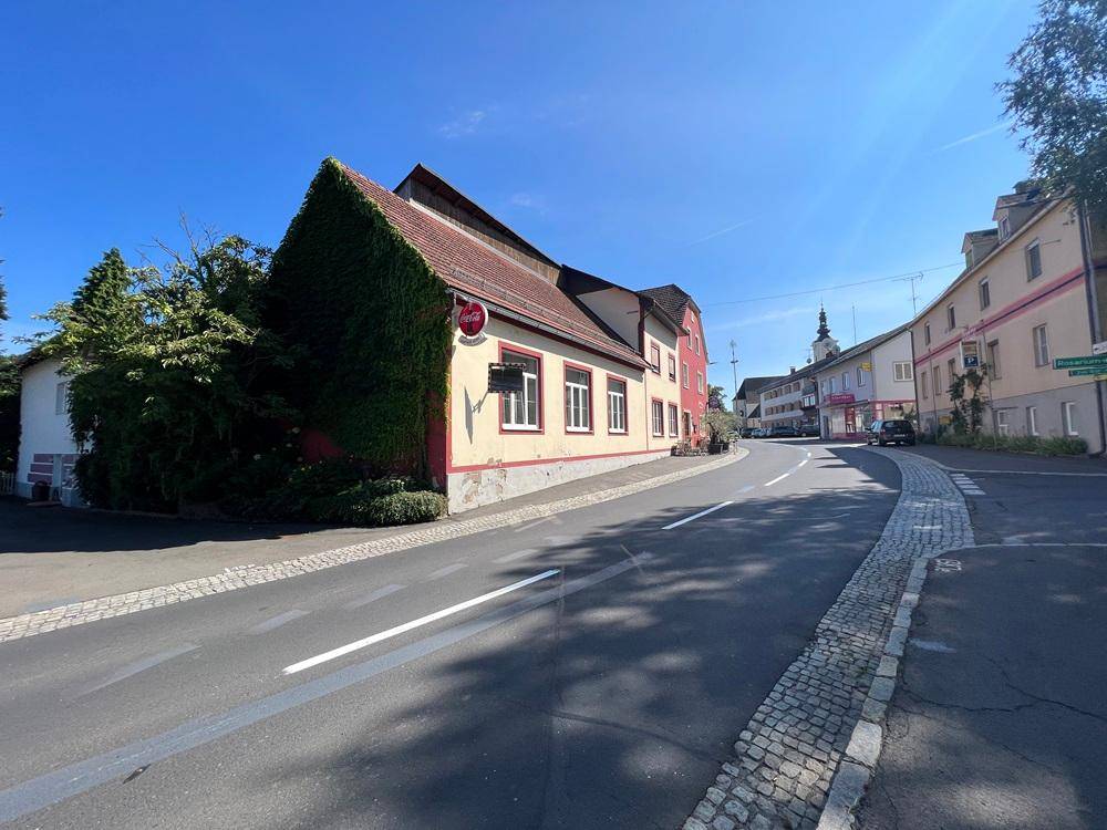 Seitenansicht des Gebäudes mit Efeu bewachsenen Wänden und Blick auf die Straße.