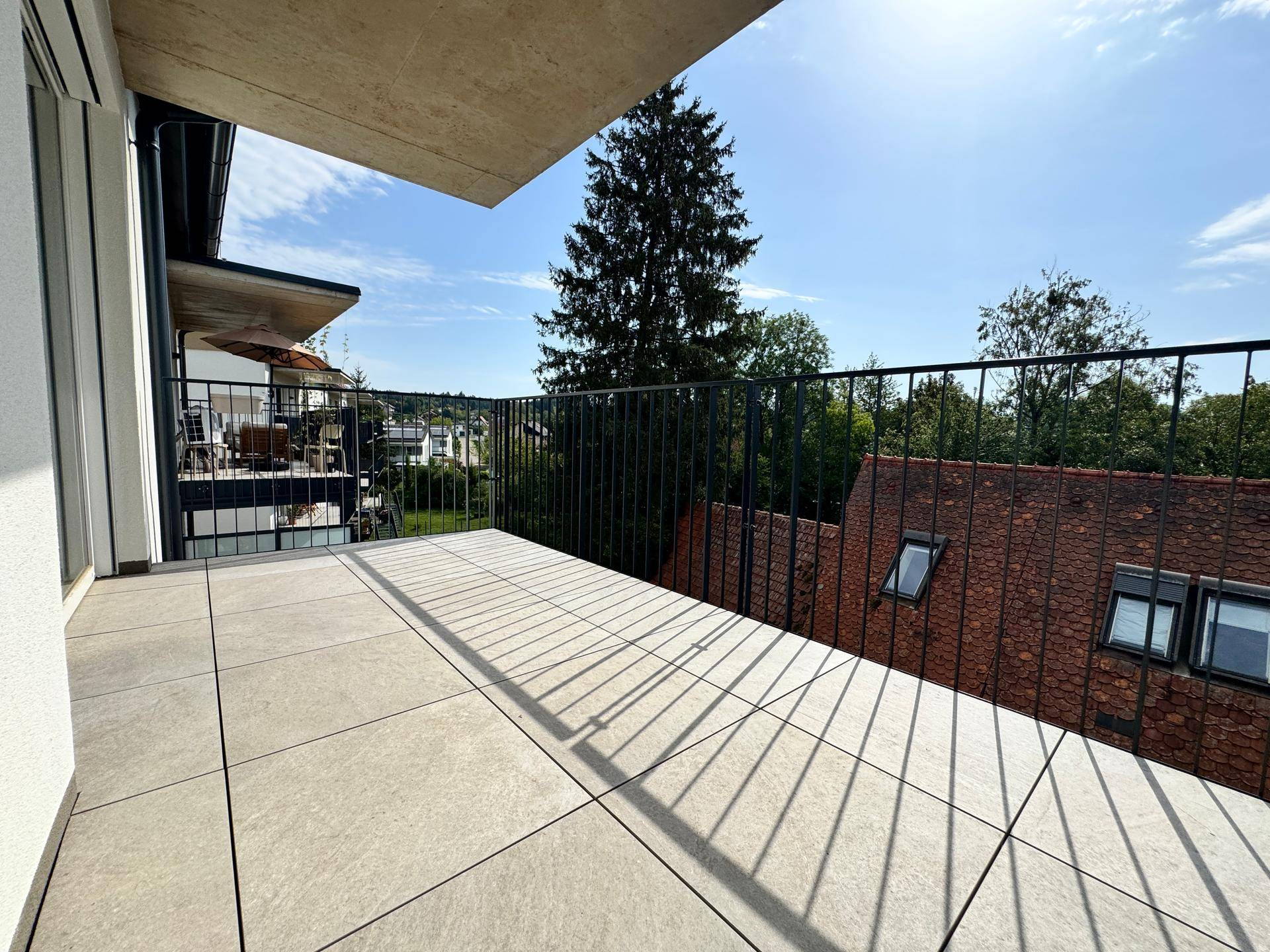 Heller Balkon mit Fliesen und Metallgeländer, bietet einen schönen Ausblick auf die Umgebung.
