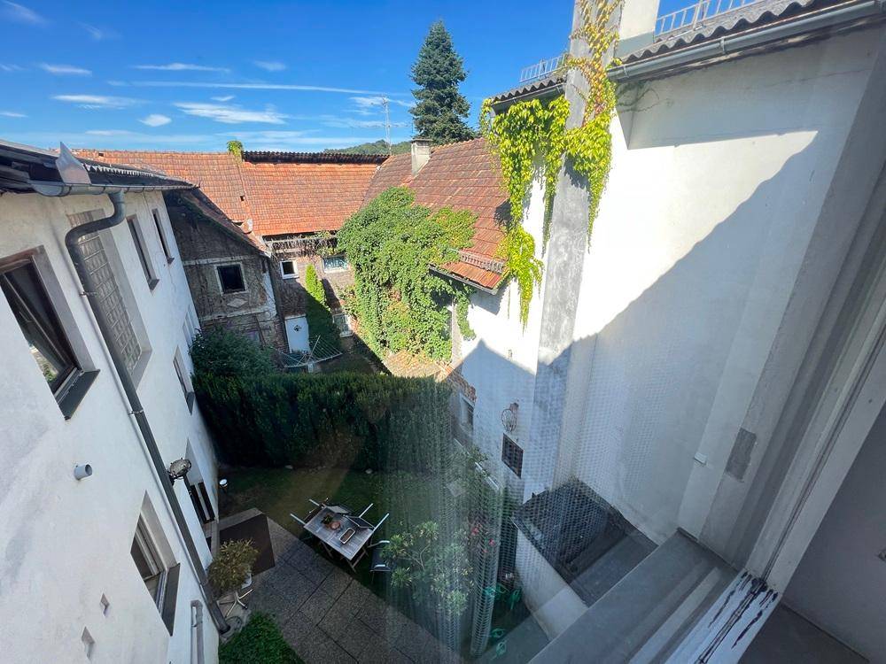Innenhof mit Grünflächen, Hecken und Blick auf die umliegenden Gebäude.