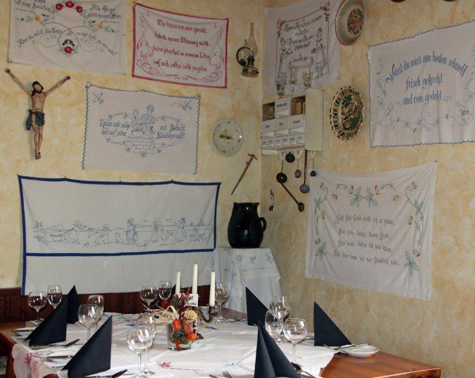 Essbereich mit traditioneller Wanddekoration, bestickten Tüchern und Holztischen.