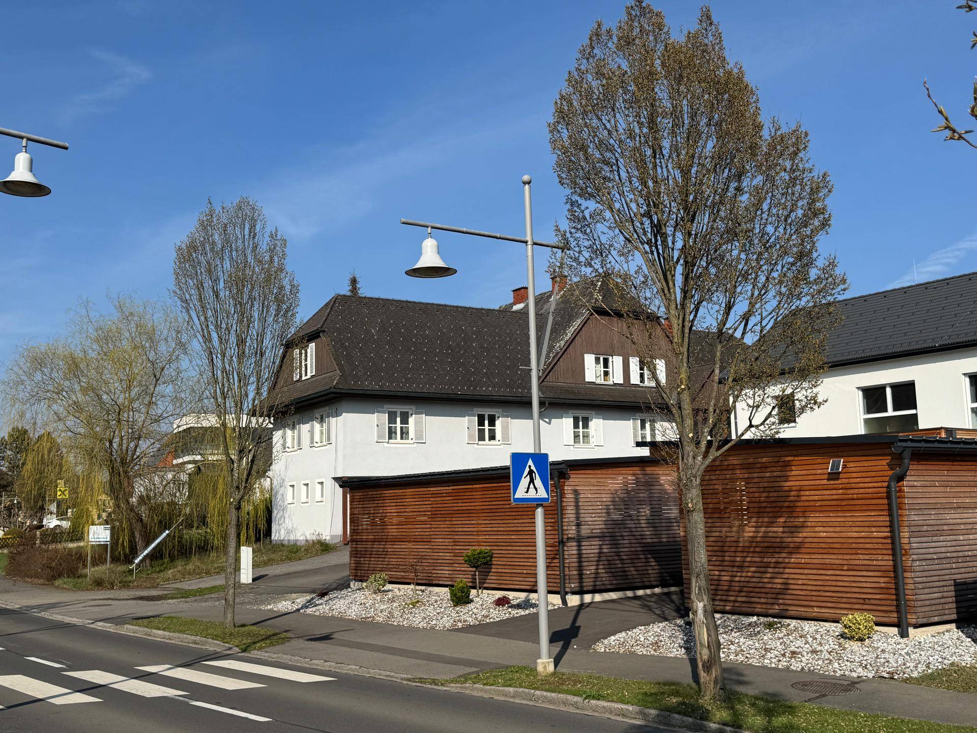 Straßenansicht mit modernen Laternen und weiteren Gebäuden in einer ruhigen Wohngegend.