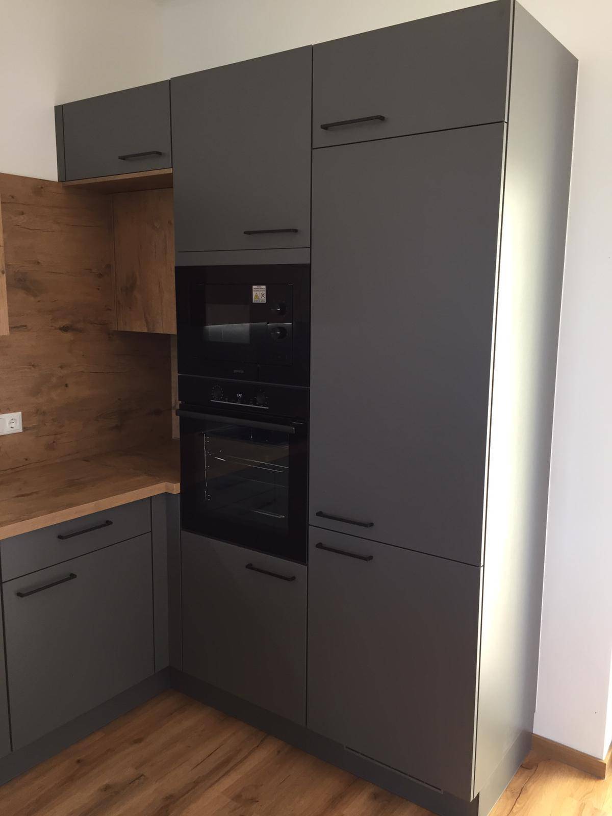 Hoher Küchenschrank mit integriertem Backofen, Mikrowelle und viel Stauraum.