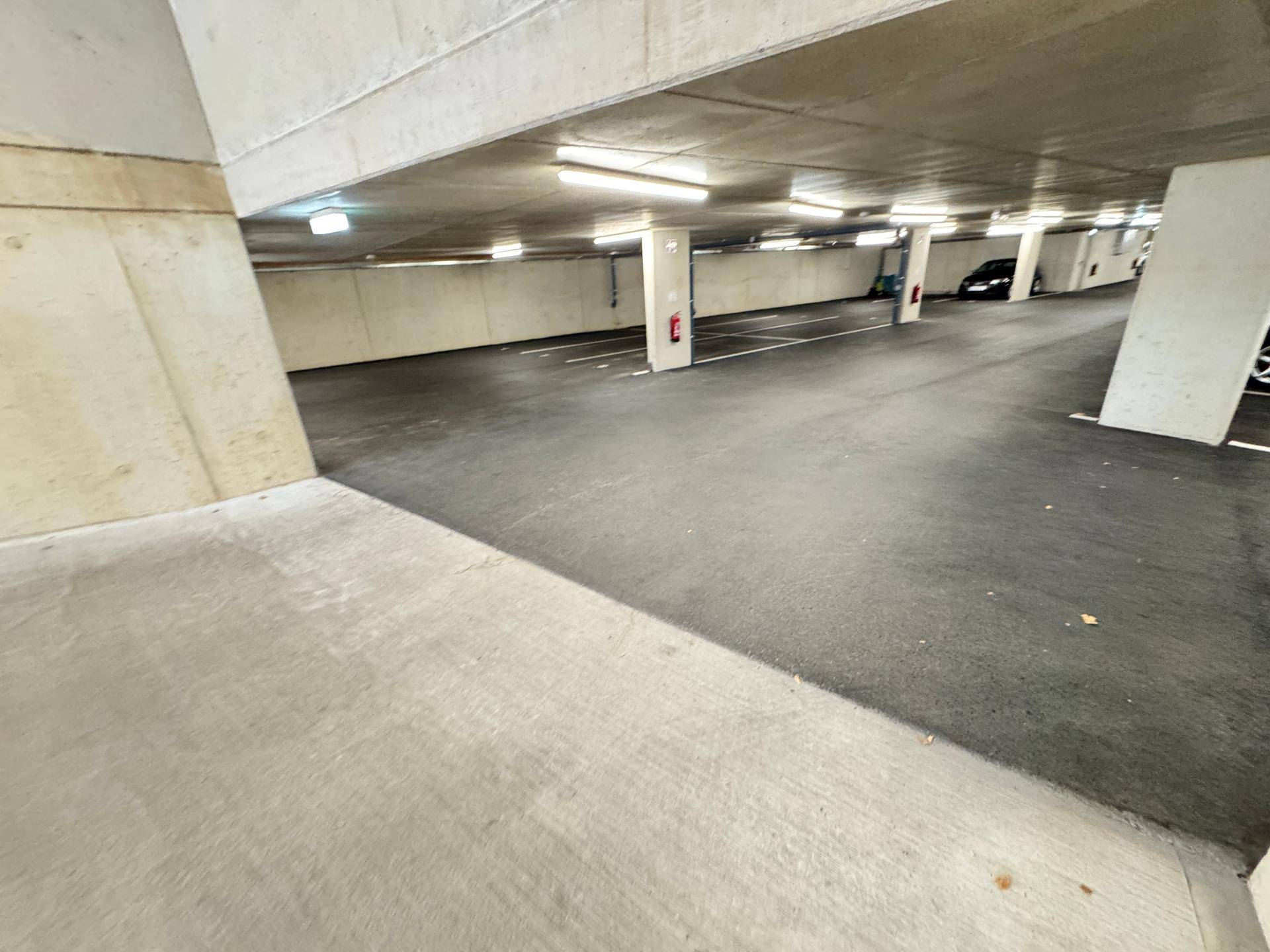 Geräumige Tiefgarage mit markierten Parkplätzen und Betonstützen.