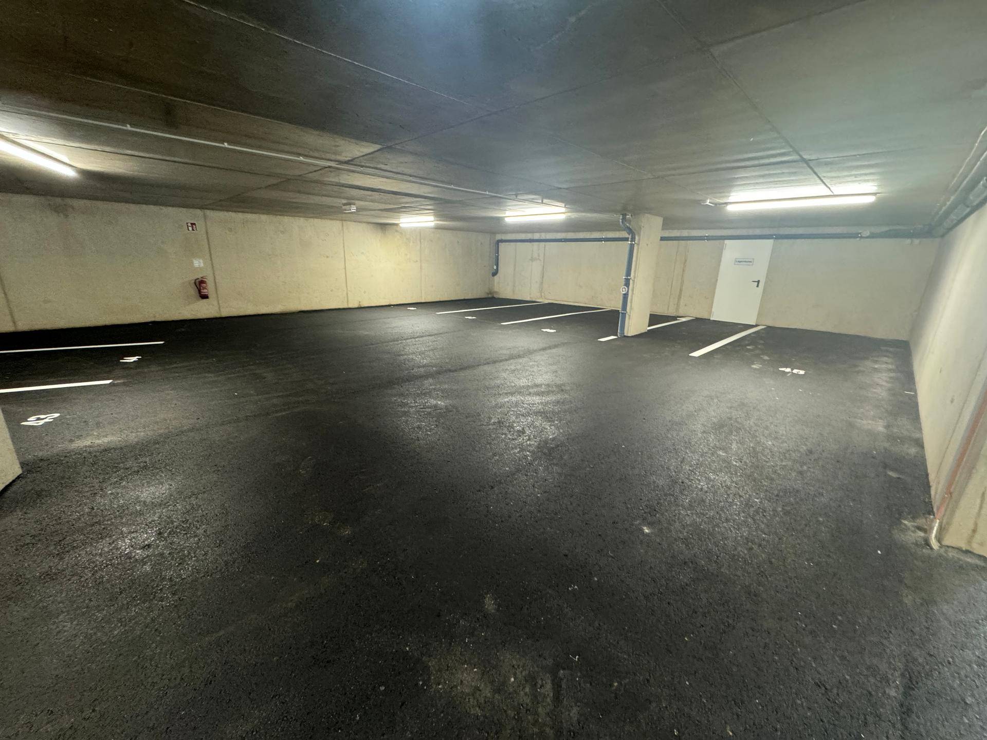 Geräumige Tiefgarage mit markierten Stellplätzen und guter Beleuchtung.