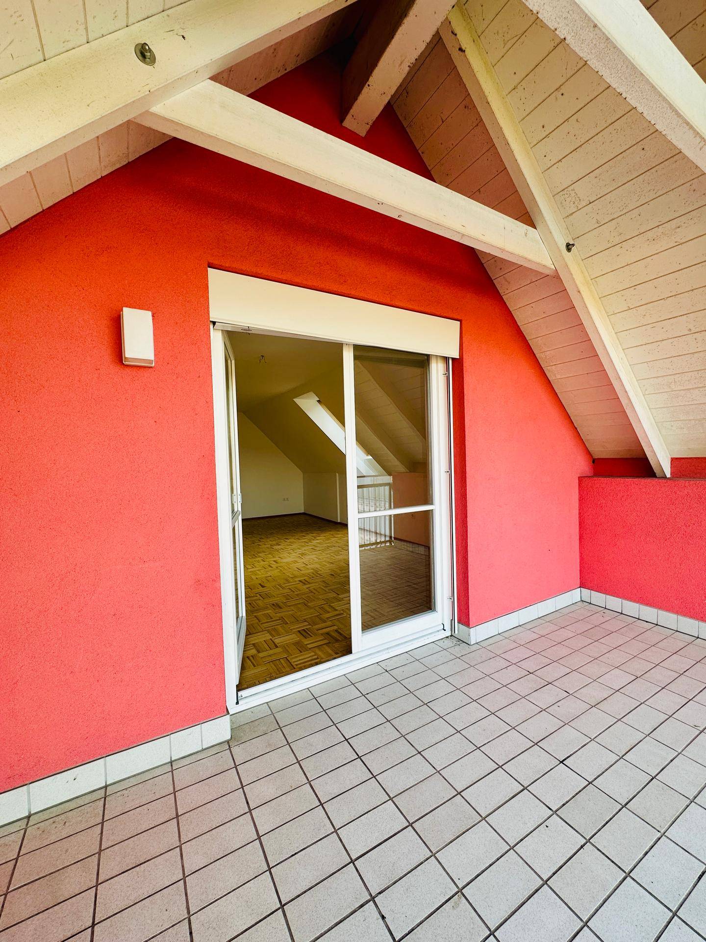 Geräumiger Balkon mit Fliesenboden und direktem Zugang zu einem hellen Innenraum.