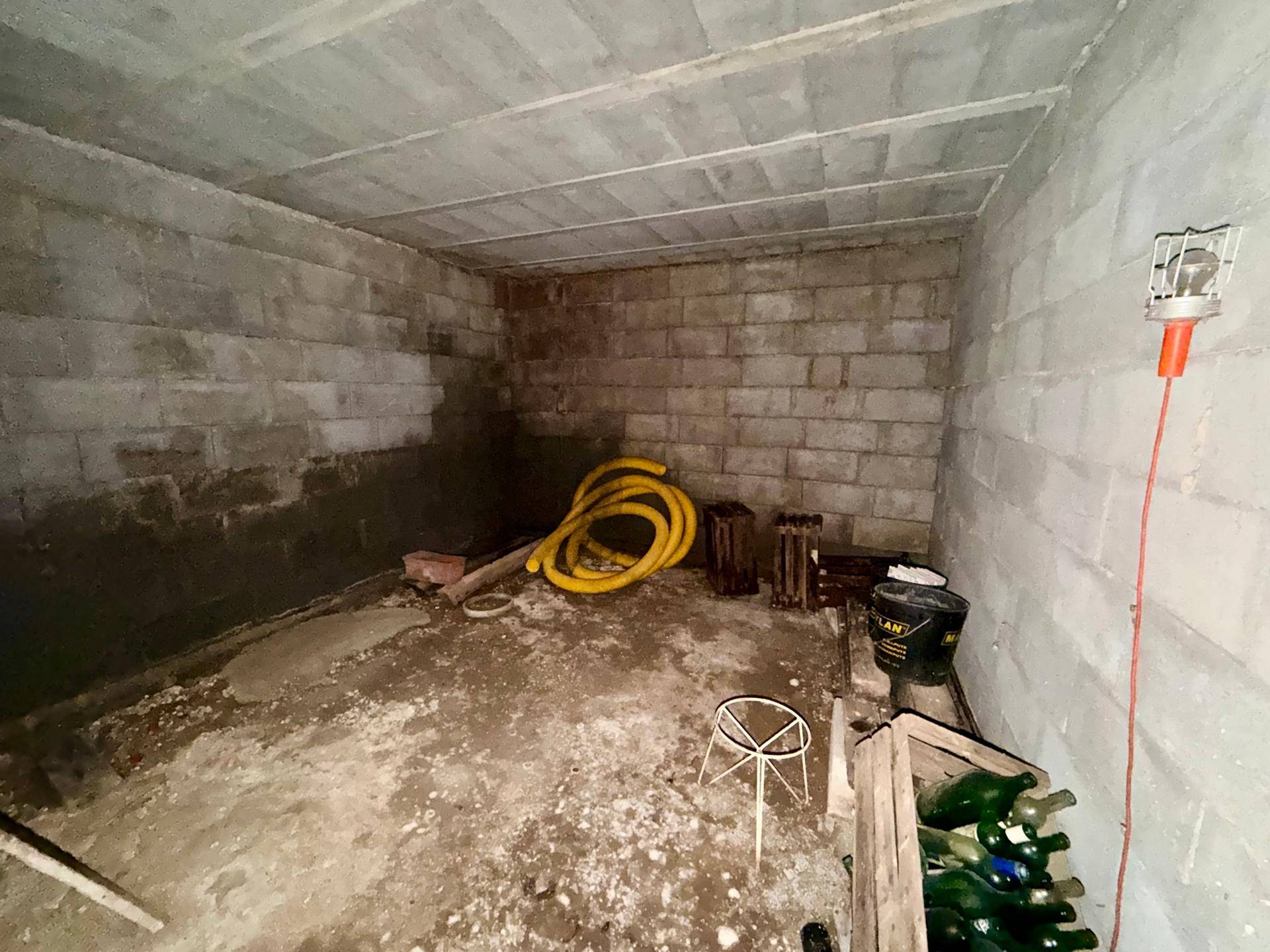 Unfertiger Kellerraum mit Betonwänden und -decke, ideal als Lagerfläche.