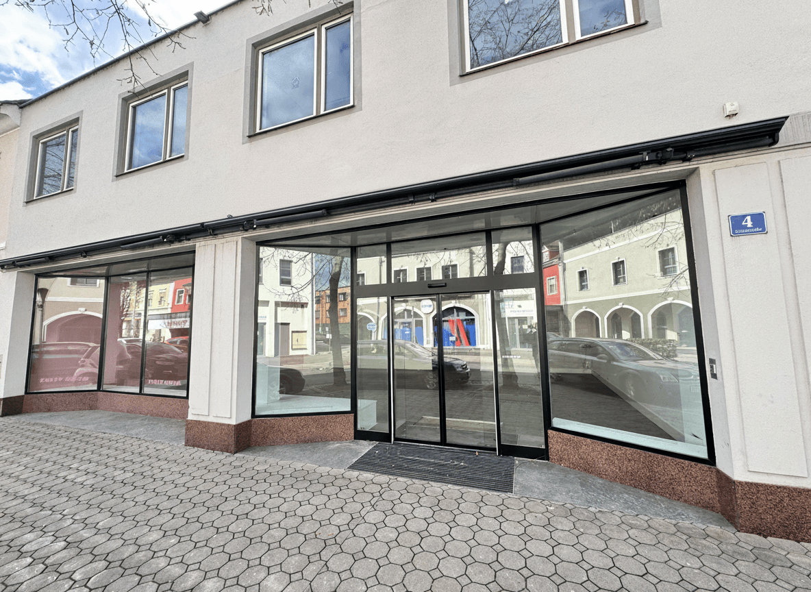 Eingangsbereich des Ladenlokals mit großen Glasfronten und automatischer Schiebetür.