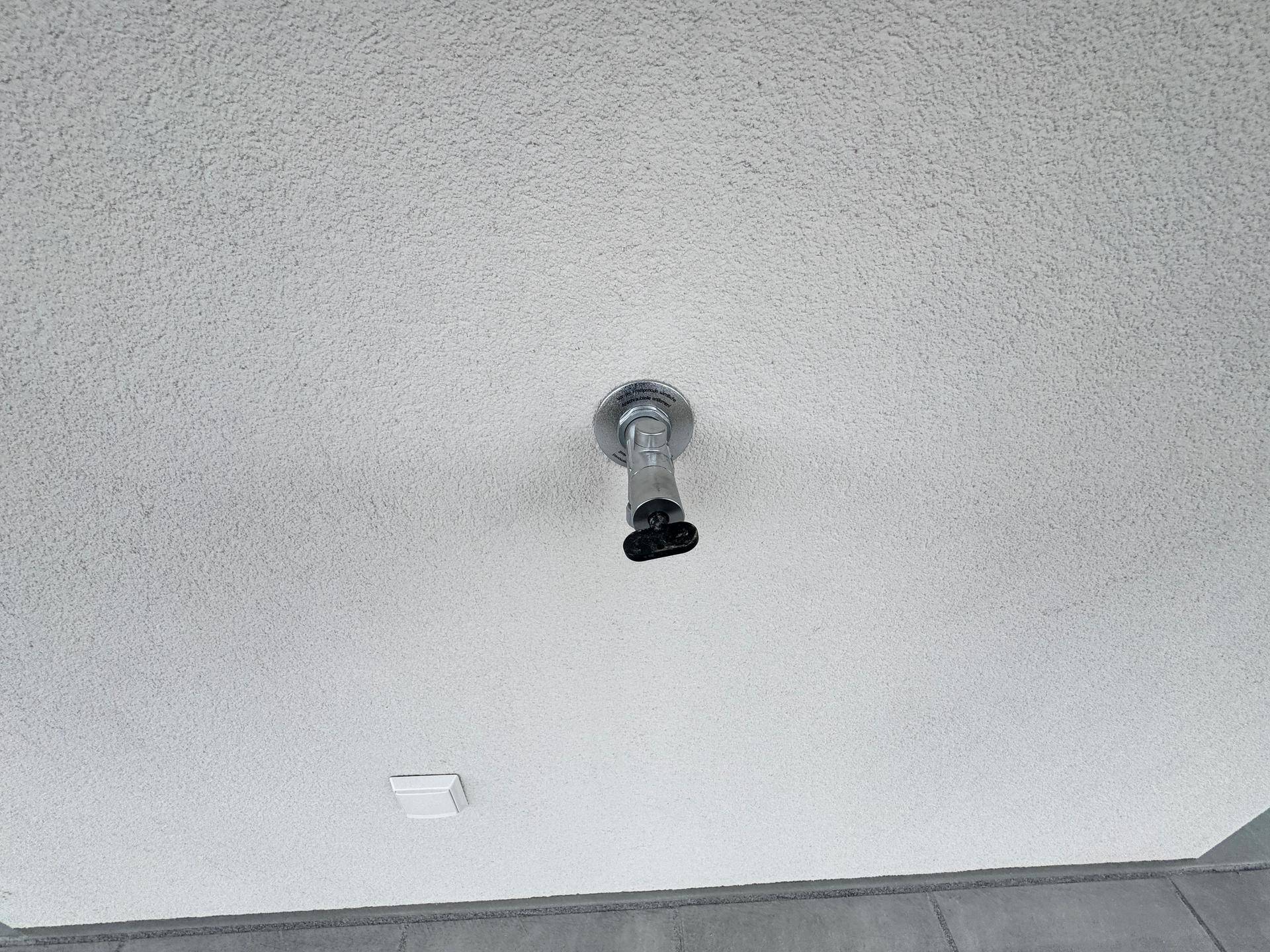Decke mit einfacher Beleuchtung und rauer Putzstruktur in einem Innenraum.
