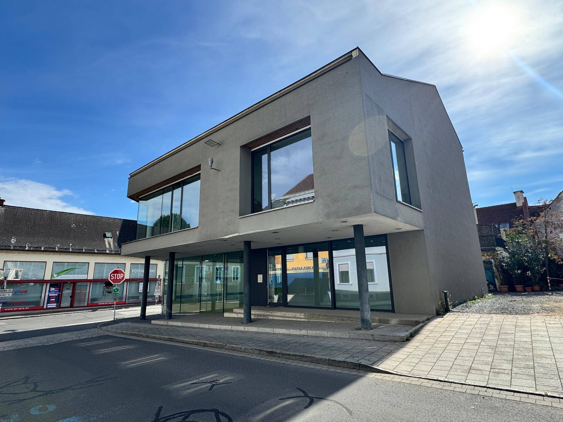Ansicht des modernen Geschäftsgebäudes mit großen Glasfenstern und klaren Linien unter strahlendem Sonnenschein.