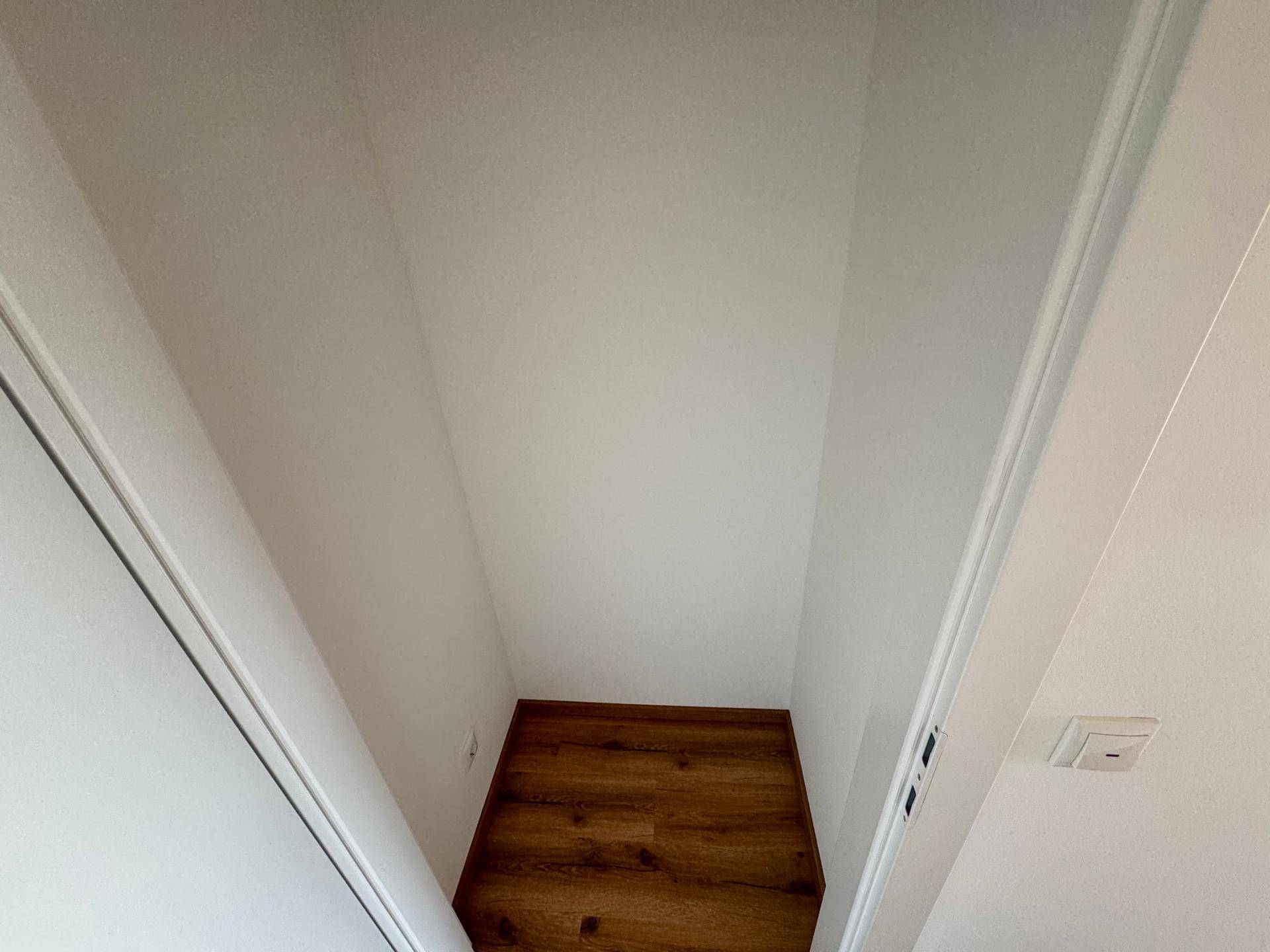 Kleiner Abstellraum mit Laminatboden und weißen Wänden, ideal für zusätzlichen Stauraum.