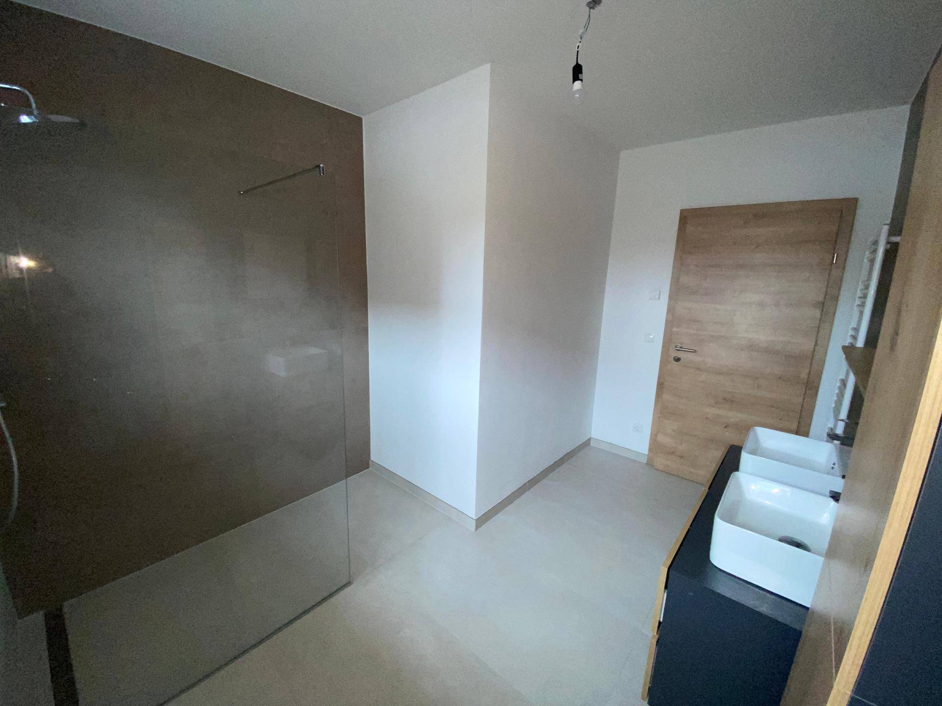 Modernes Badezimmer mit großer begehbarer Dusche und Doppelwaschbecken.