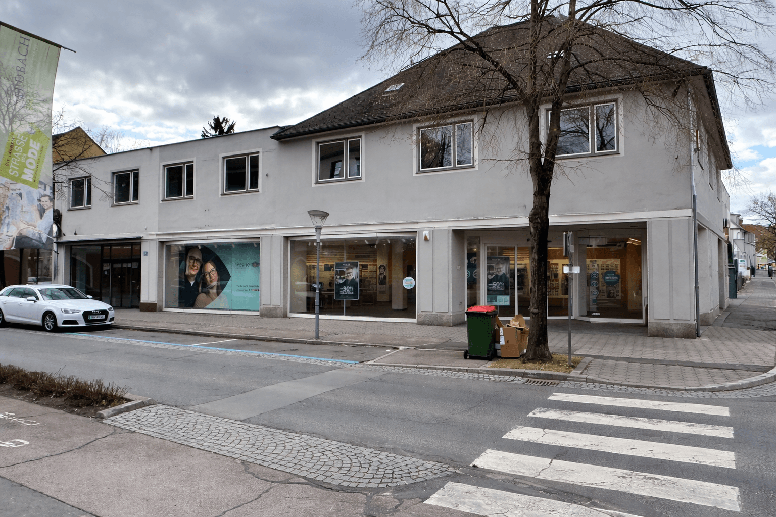 Fassade des Gebäudes mit mehreren Schaufenstern im Erdgeschoss und Fenstern in den oberen Etagen.