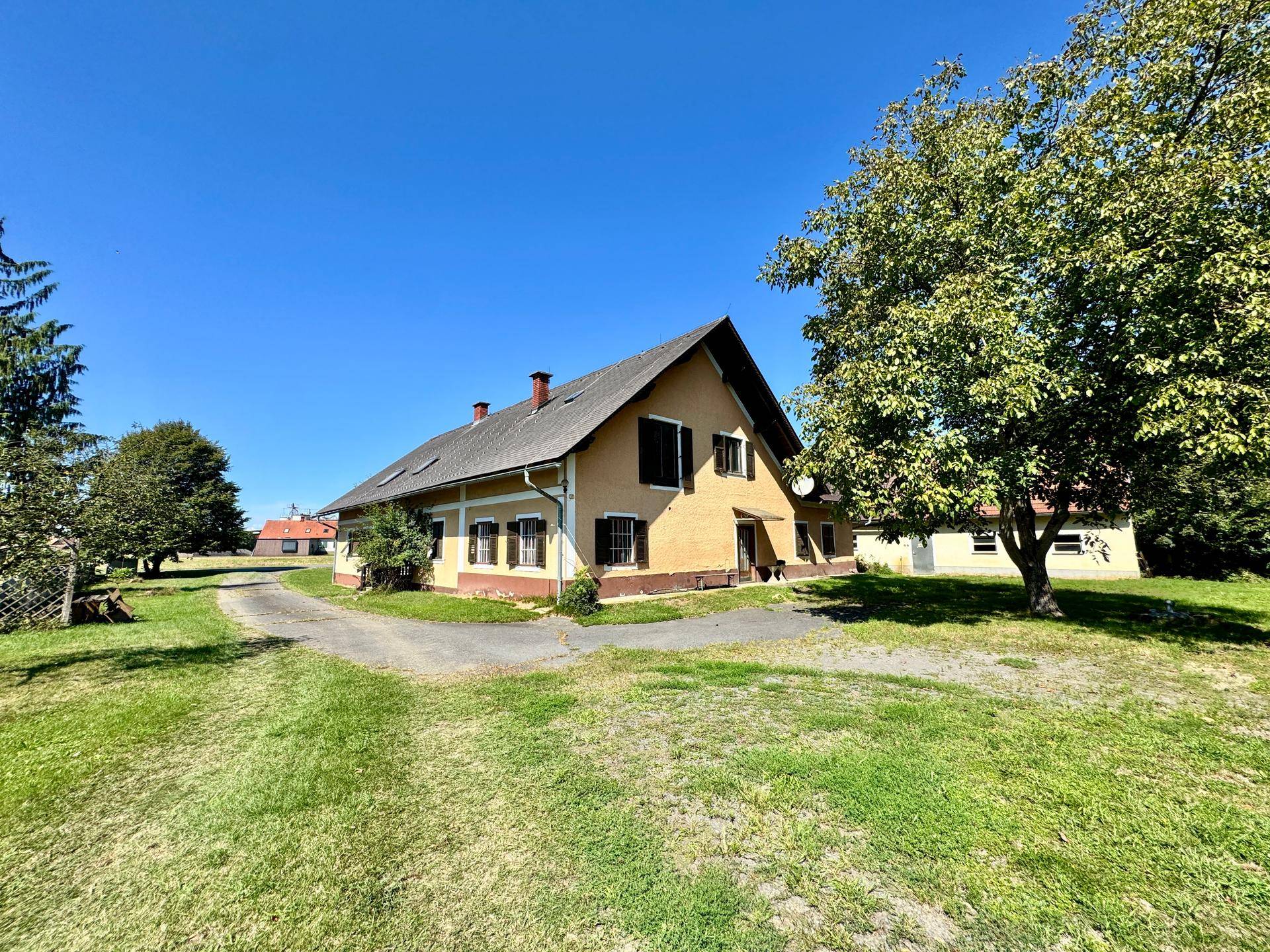 Weitläufiges Grundstück mit traditionellem Landhaus und altem Baumbestand.