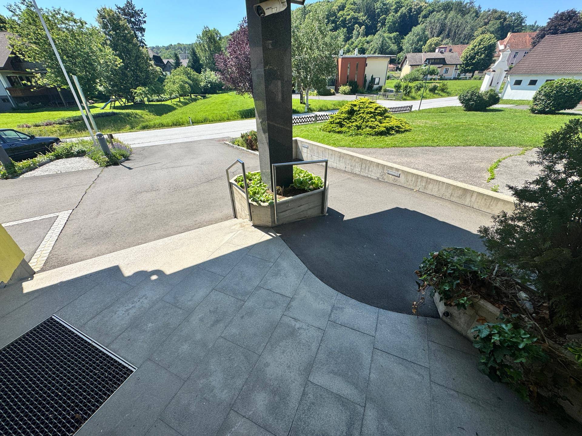 Blick vom Eingangsbereich auf die ländliche Umgebung mit Straße, Häusern und viel Grün.