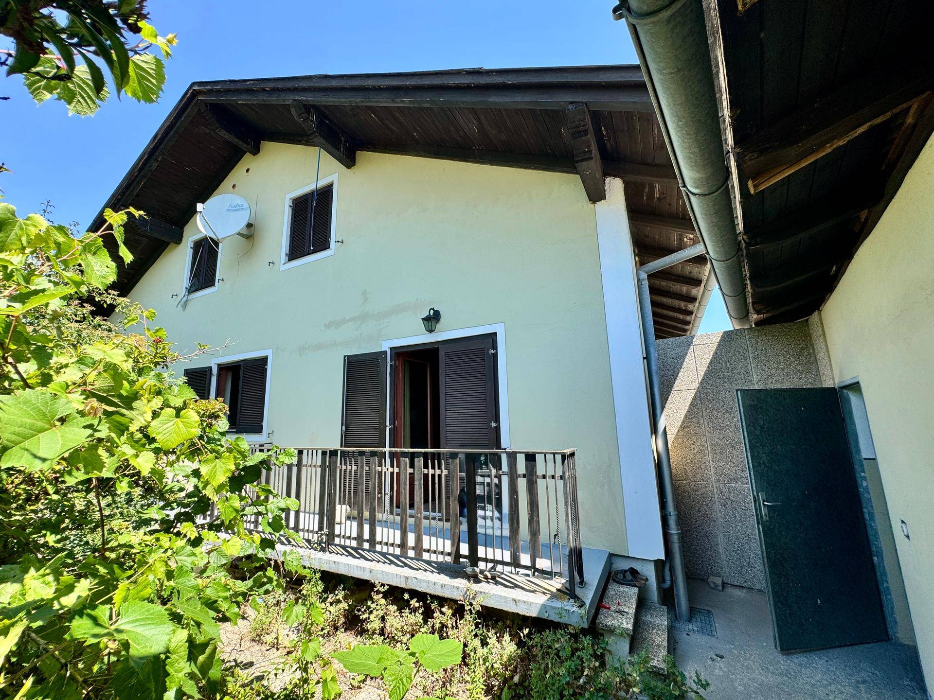Kleiner Balkon an der Hausseite mit Holzbalken und Blick ins Grüne.