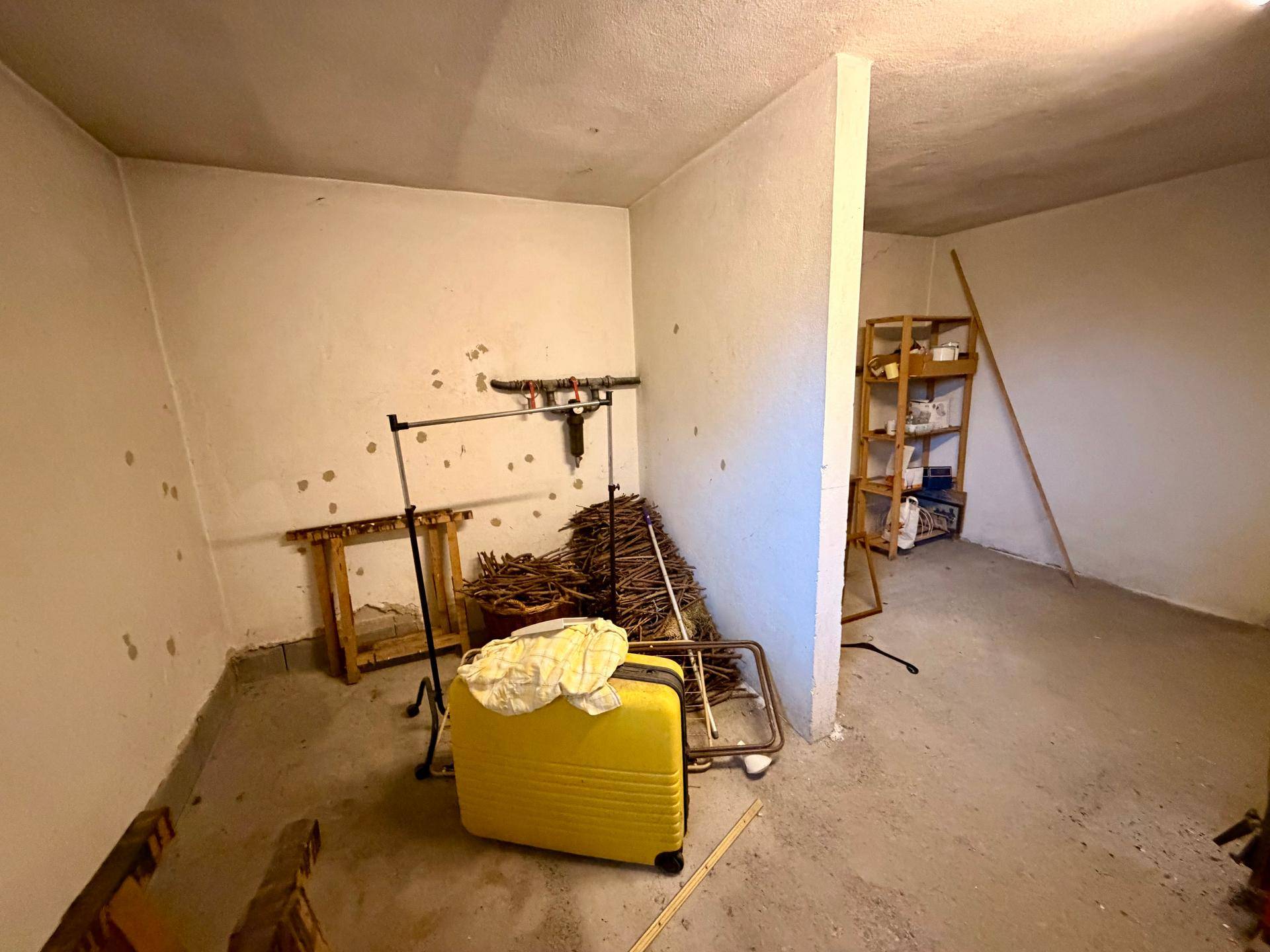 Geräumiger Abstellraum im Keller mit einfachen Regalen und viel Platz.