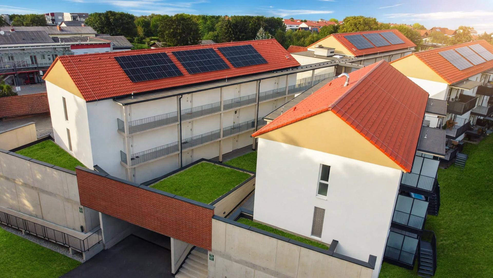 Übersicht des Wohnkomplexes mit grünen Dächern, Solaranlagen und modernen Gebäudestrukturen.