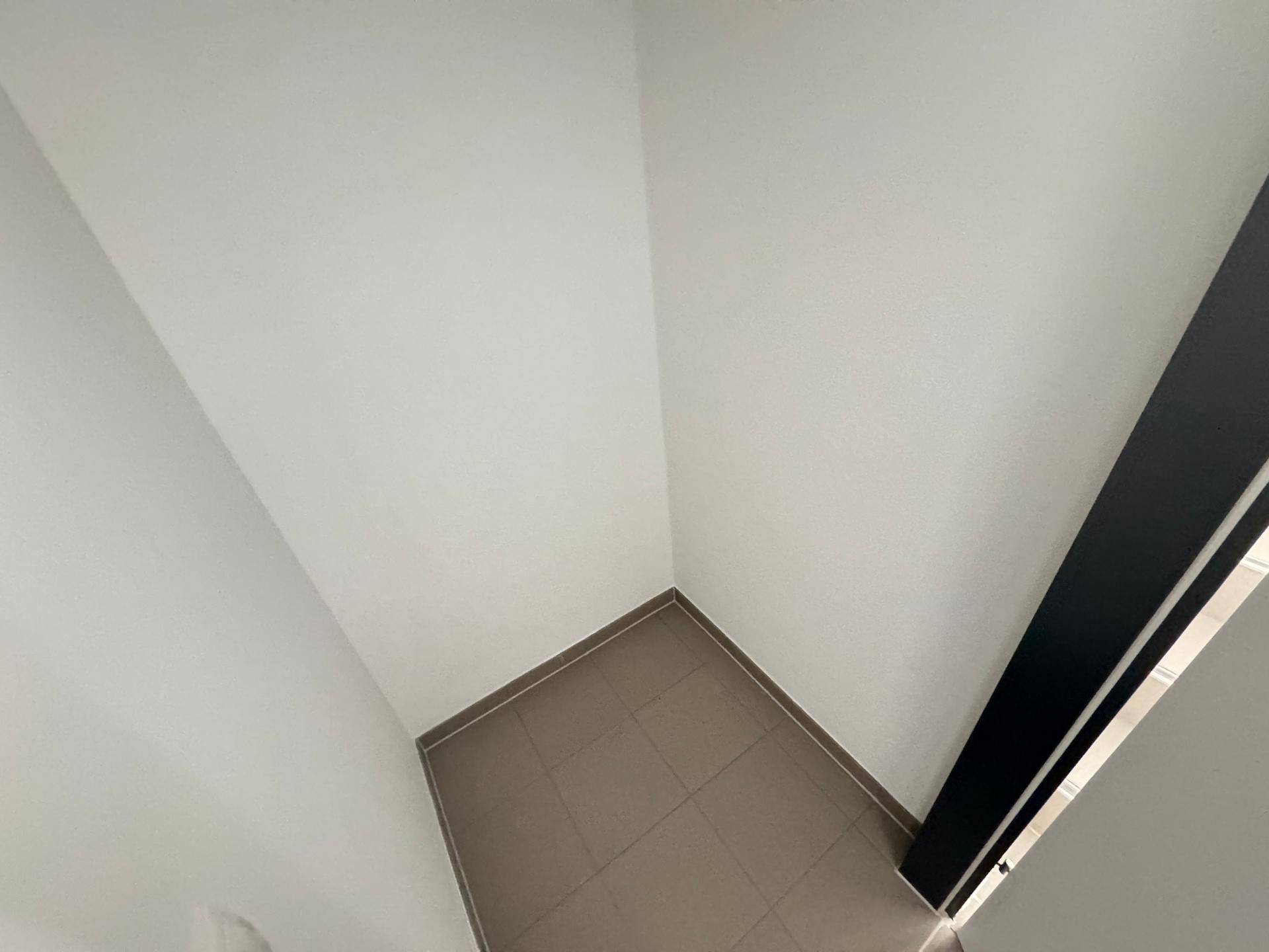 Kleiner, gefliester Raum mit WC und Waschbecken.