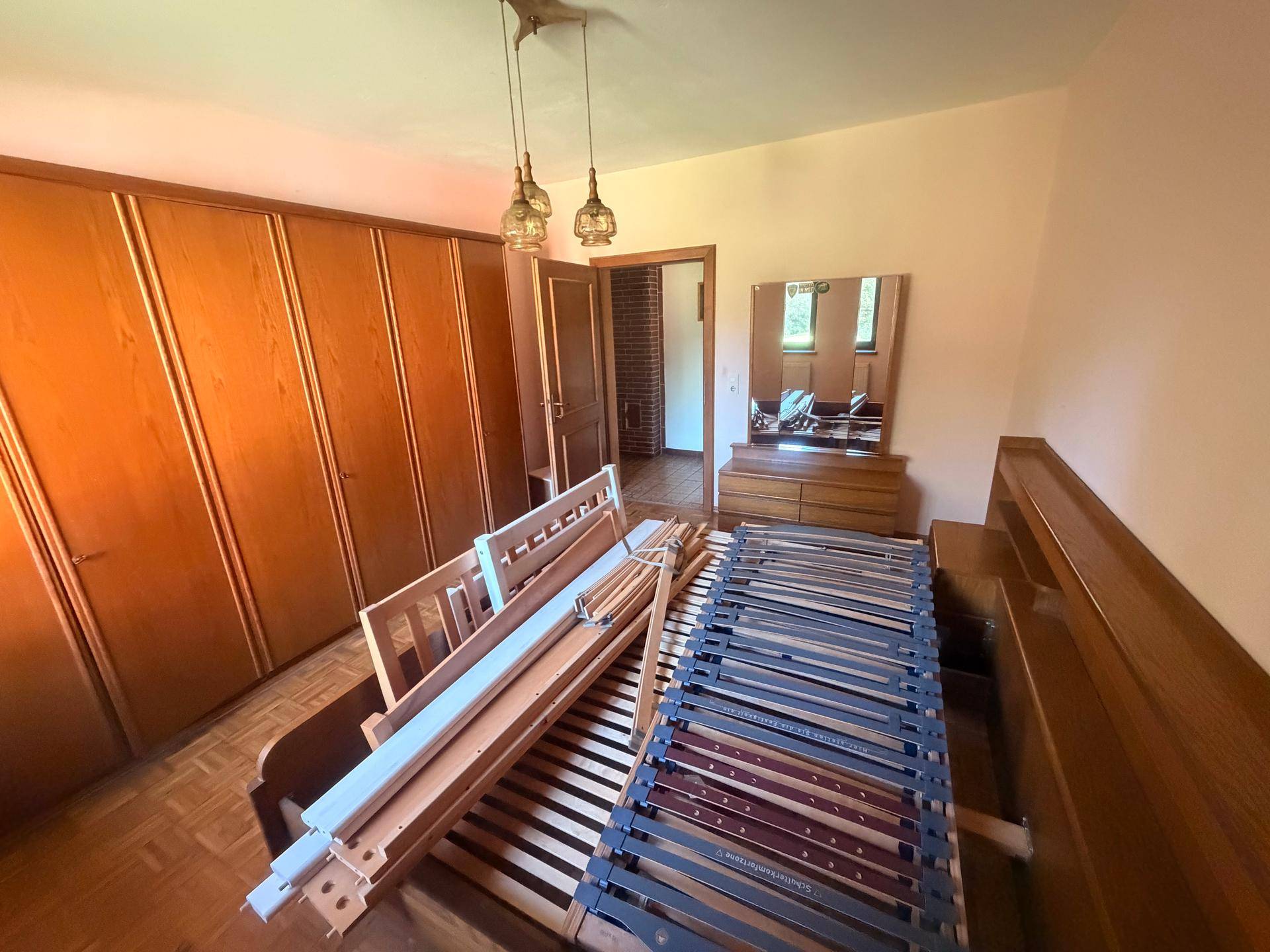 Schlafzimmer mit Einbauschränken, Holzboden und Bettgestell.