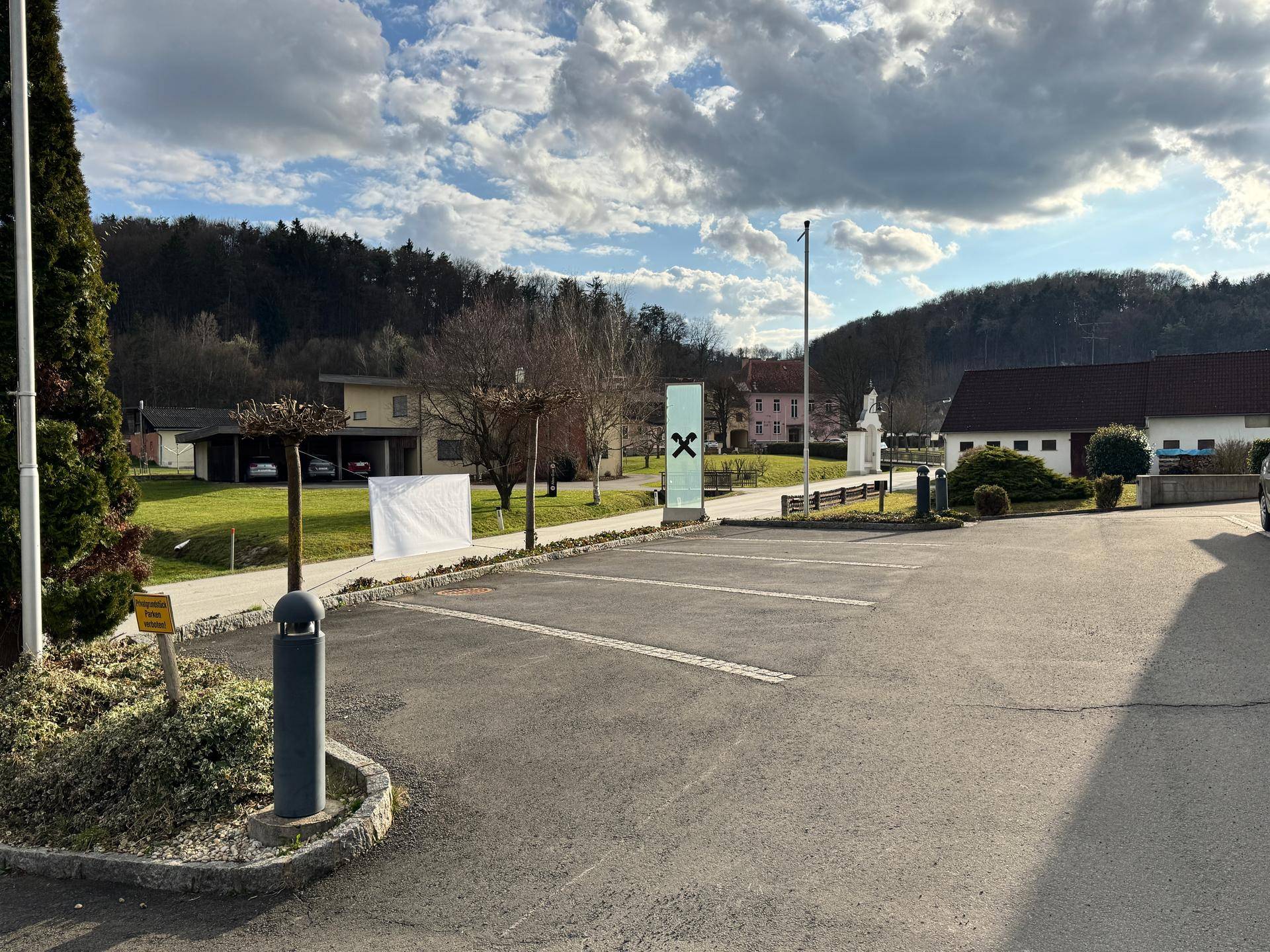 Parkplatzbereich mit umliegender Natur und Blick auf die ländliche Umgebung.