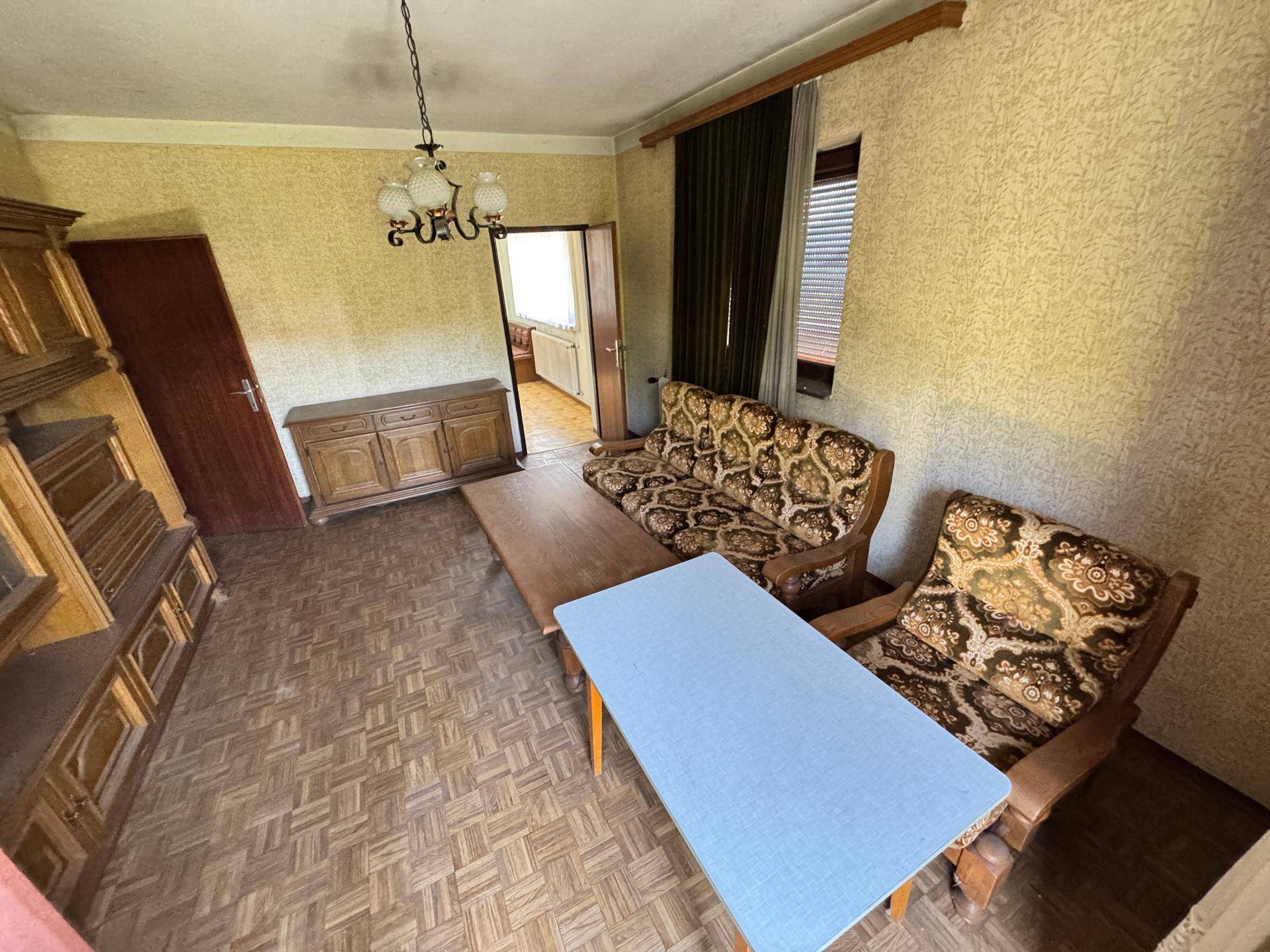 Wohnzimmer mit traditionellen Möbeln, gemustertem Boden und Blick in den Flur.