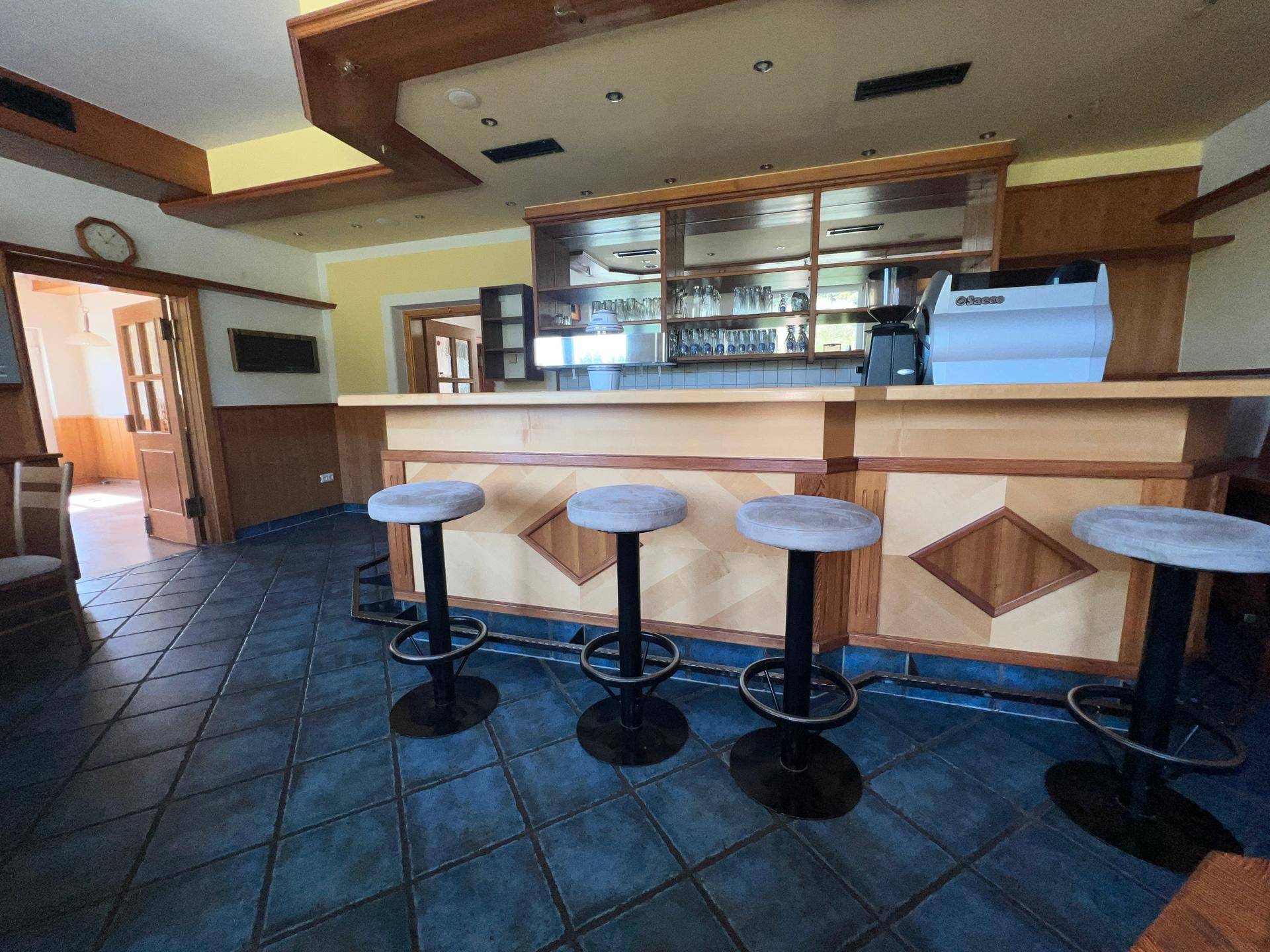 Barbereich mit Theke, Barhockern und Spiegeln, bereit für den Service.