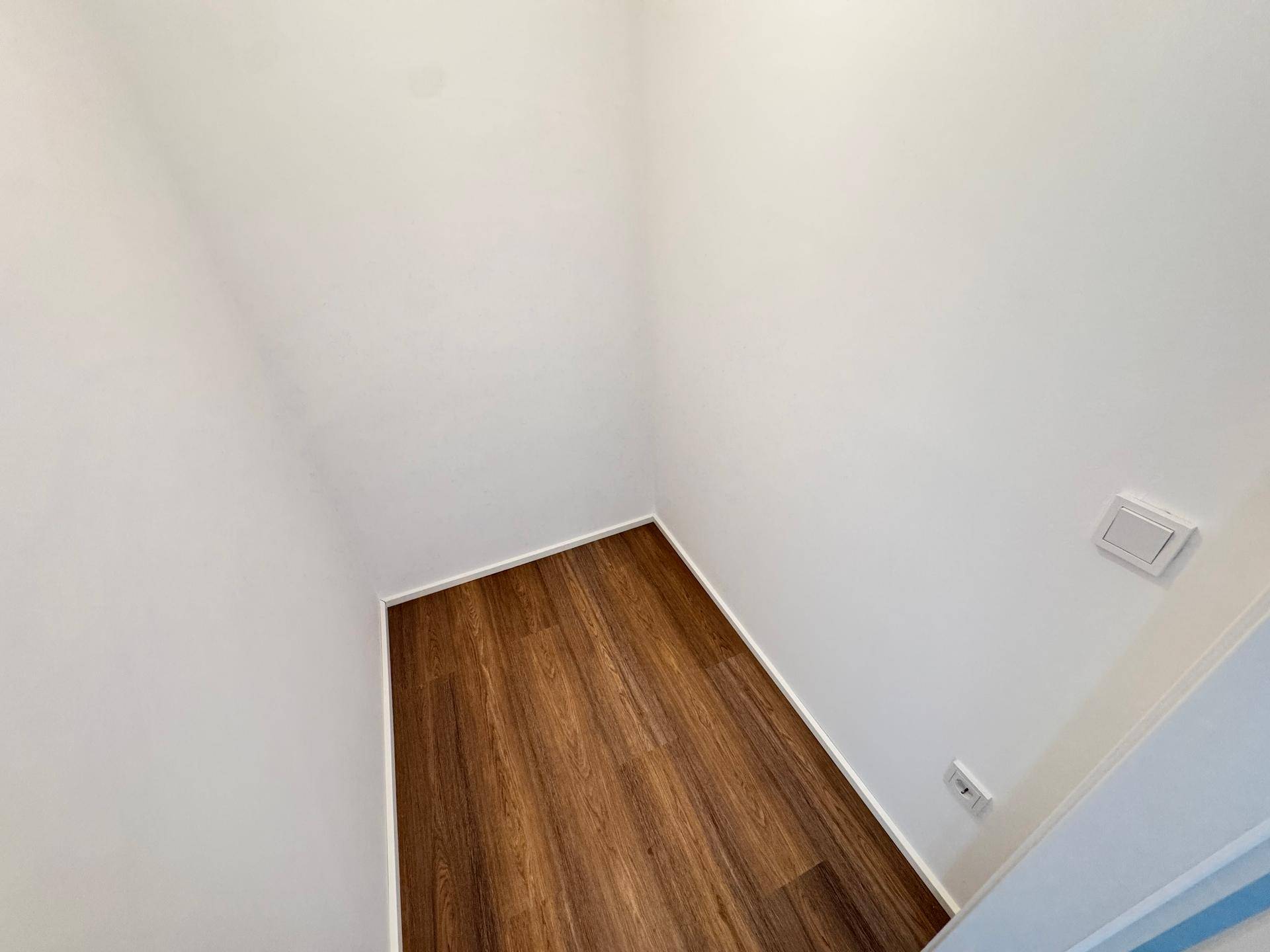 Kleiner Abstellraum mit Holzboden und weißen Wänden, ideal für zusätzlichen Stauraum.