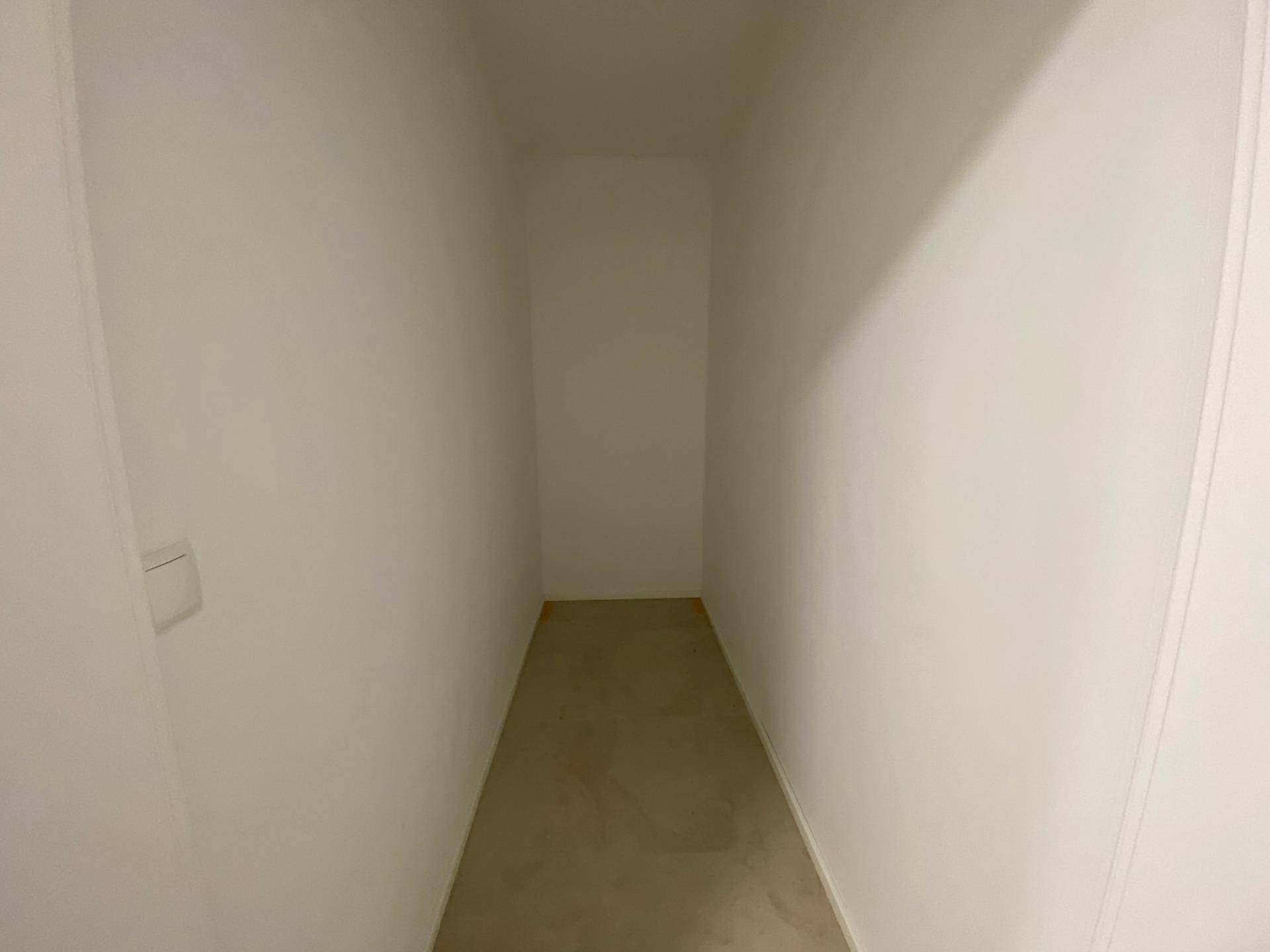 Schmaler Abstellraum mit hellen Wänden und Boden, ideal für zusätzlichen Stauraum.