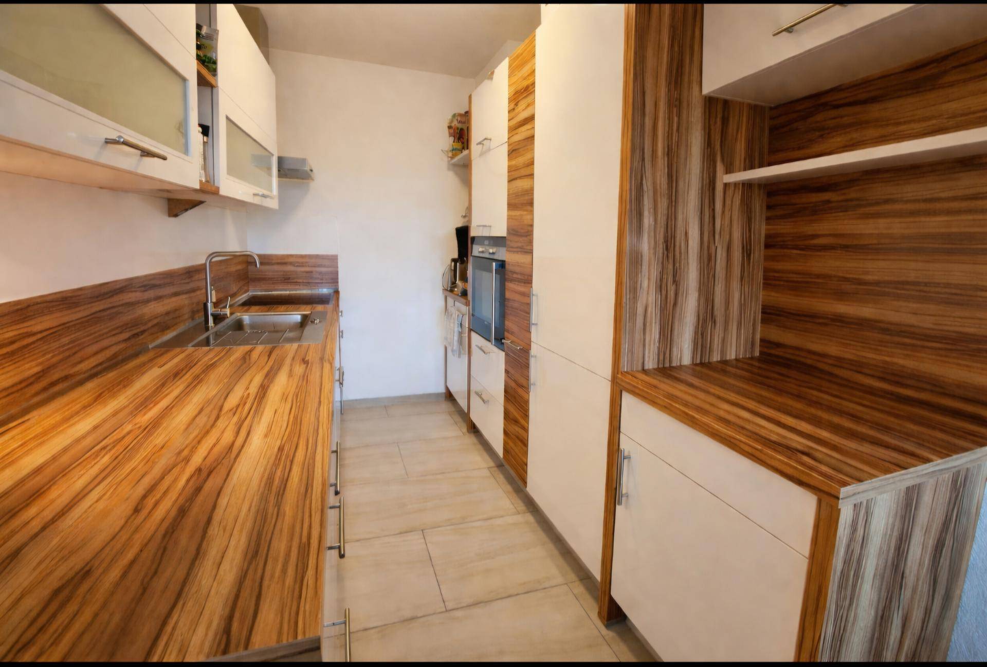 Moderne Küche mit Holz- und weißen Fronten, ausgestattet mit Einbaugeräten.