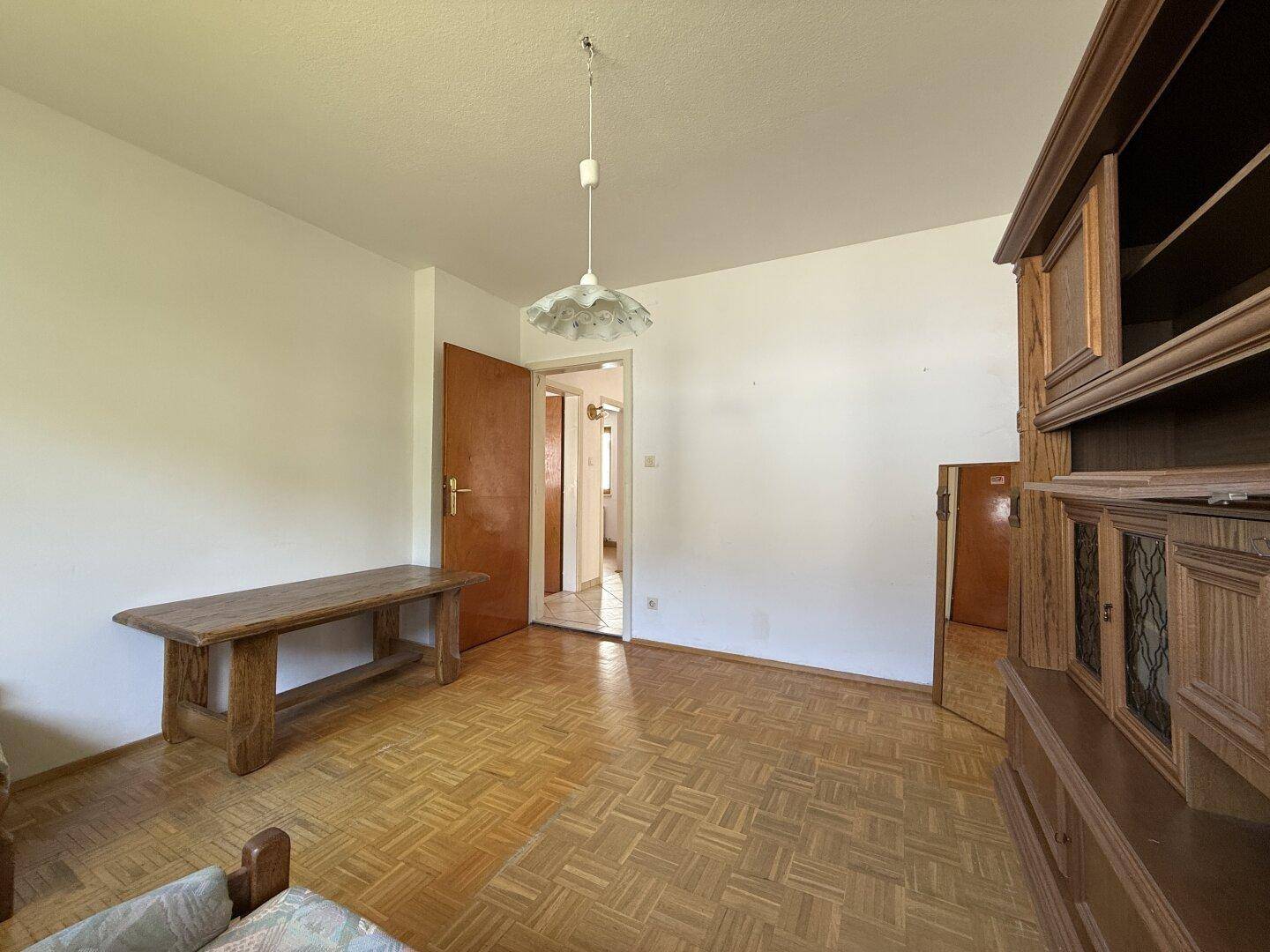 Schlafzimmer mit Parkettboden und traditionellen Holzmöbeln, bietet vielseitige Nutzungsmöglichkeiten.