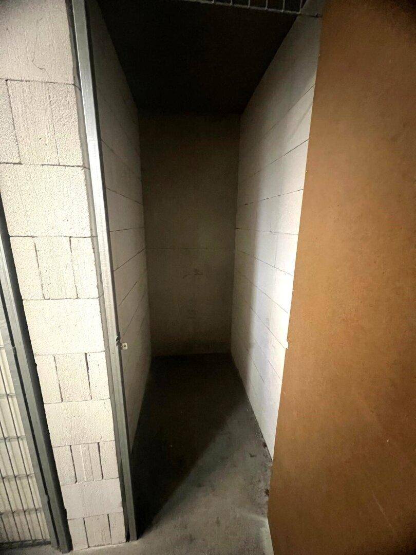 Leerer Abstellraum mit unverputzten Betonsteinwänden und dunklem Boden.