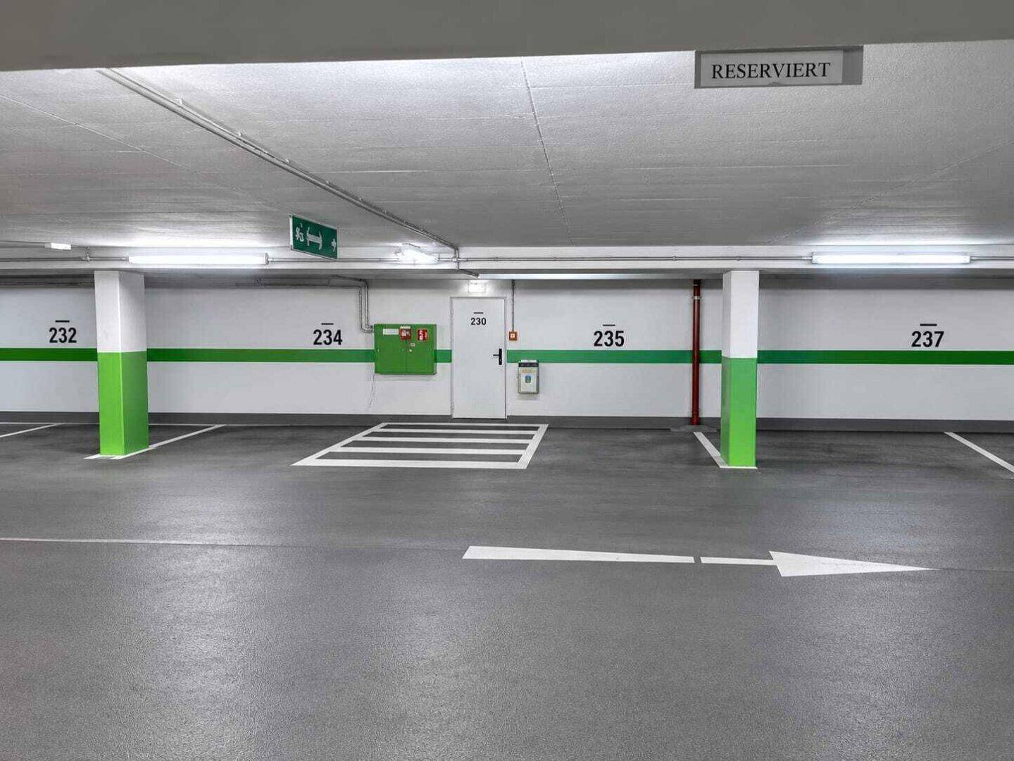 Saubere Tiefgarage mit reservierten Parkplätzen, klaren Markierungen und guter Beleuchtung.