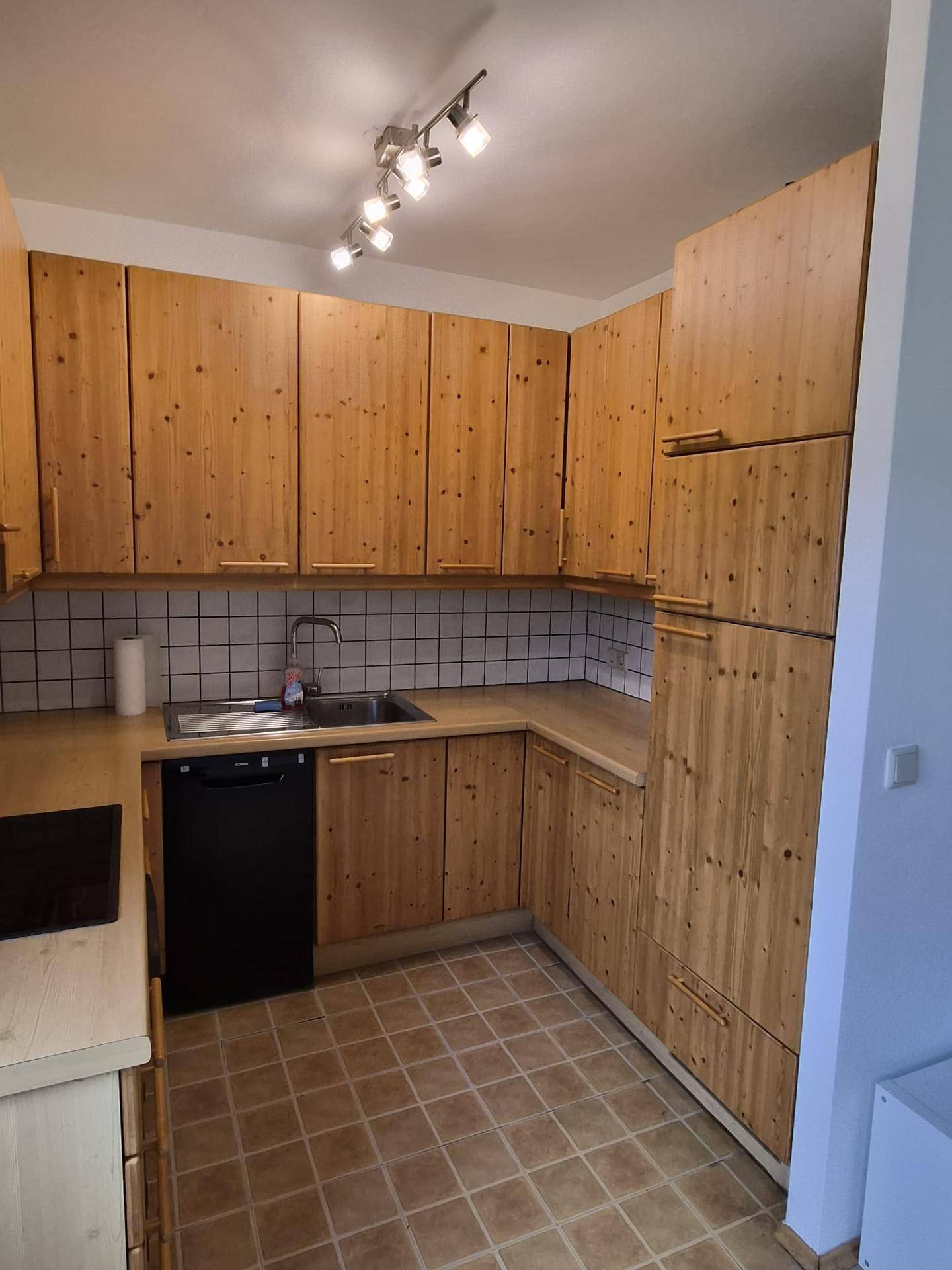 Voll ausgestattete Holzküche mit viel Stauraum, Spüle und modernen Kochgeräten.