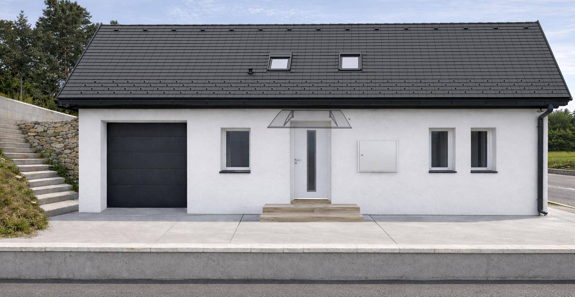 Rückseite des modernen Hauses mit Garage, Eingangstür und kleinen Fenstern.
